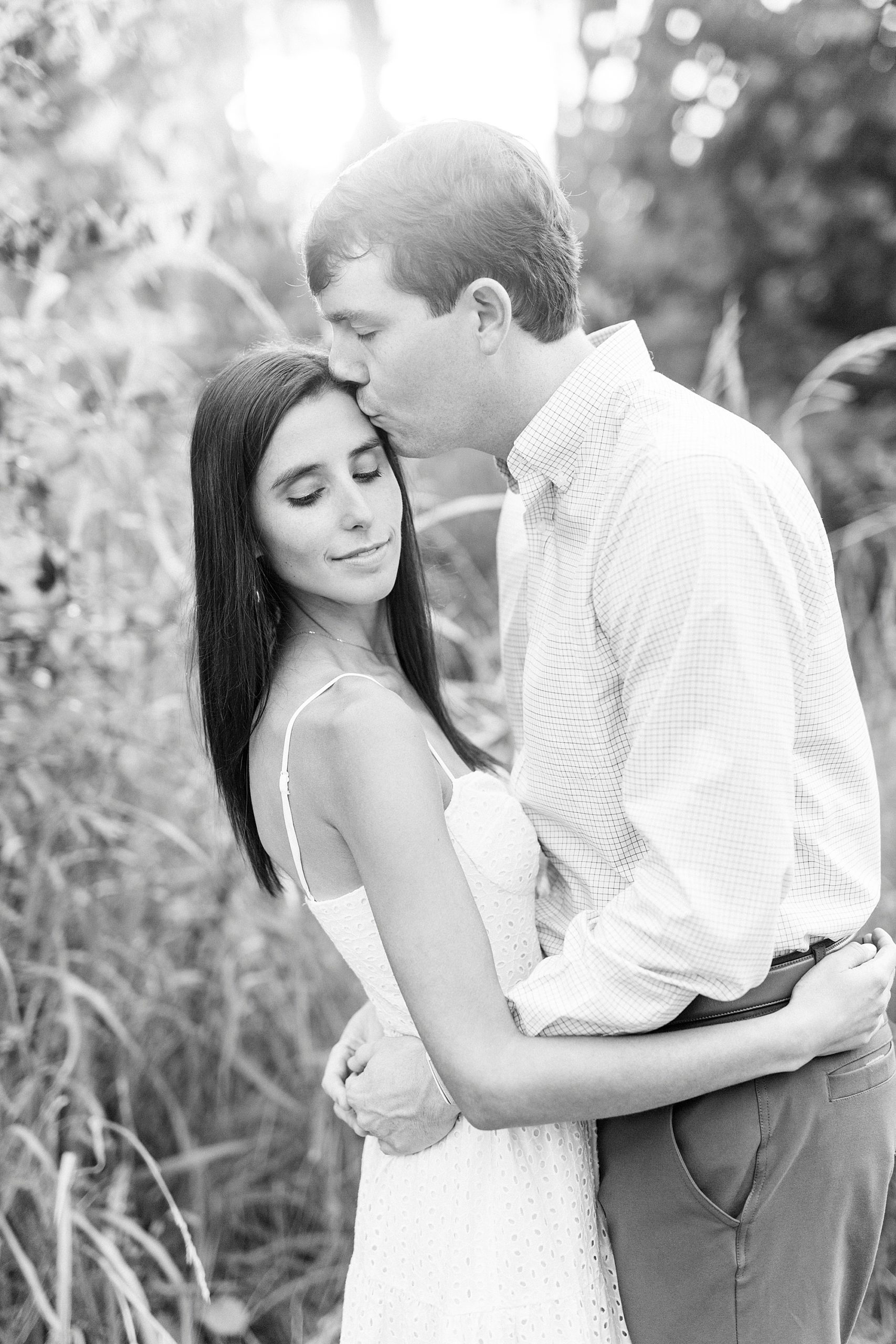 groom kisses bride's forehead in Charlotte NC park