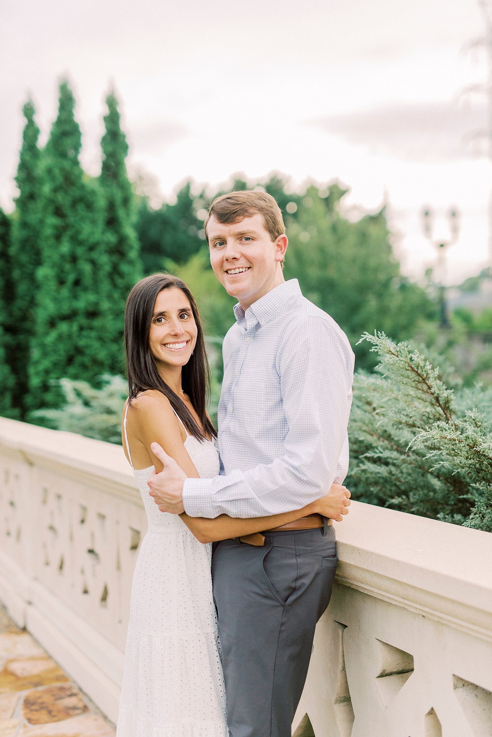 bride and groom hug on stone bridge in Midtown Park
