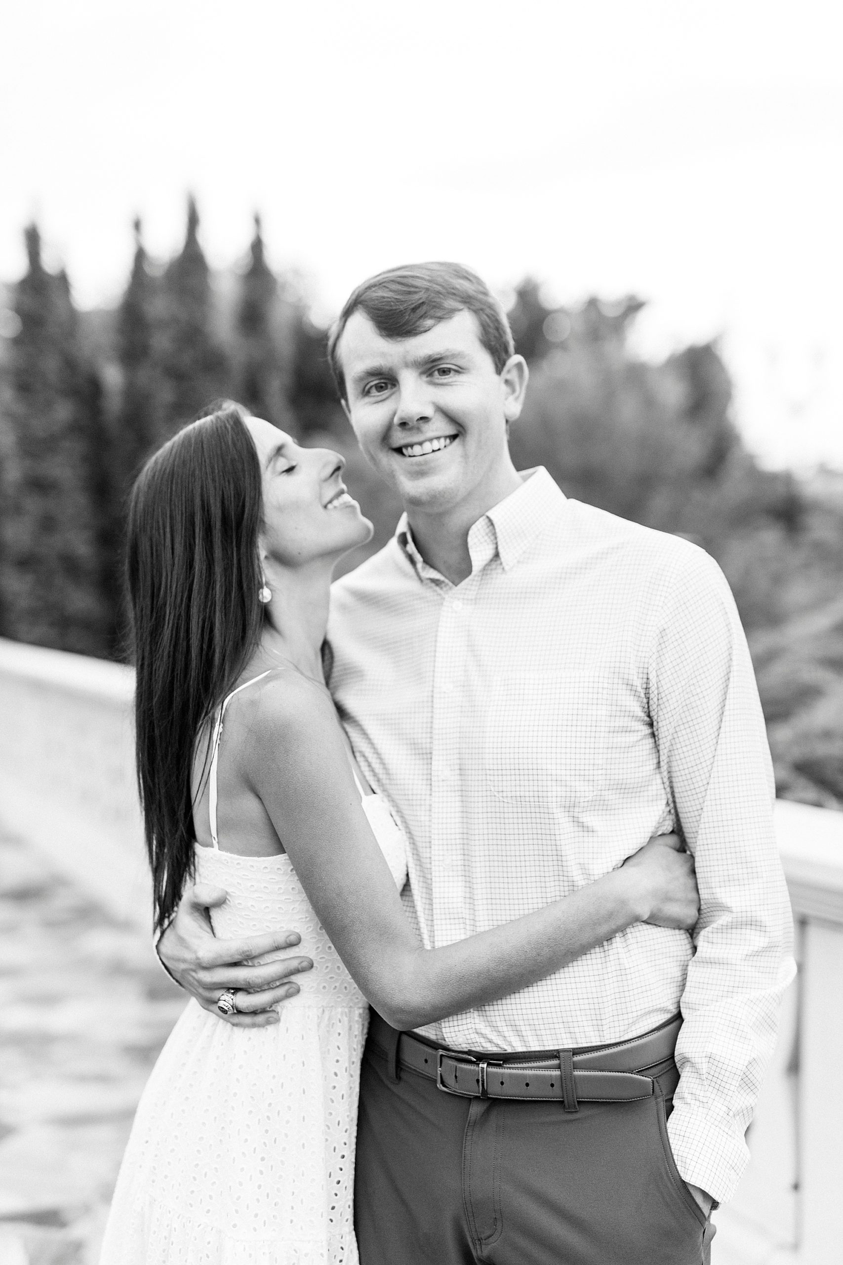 bride looks up at fiancee smiling during engagement session