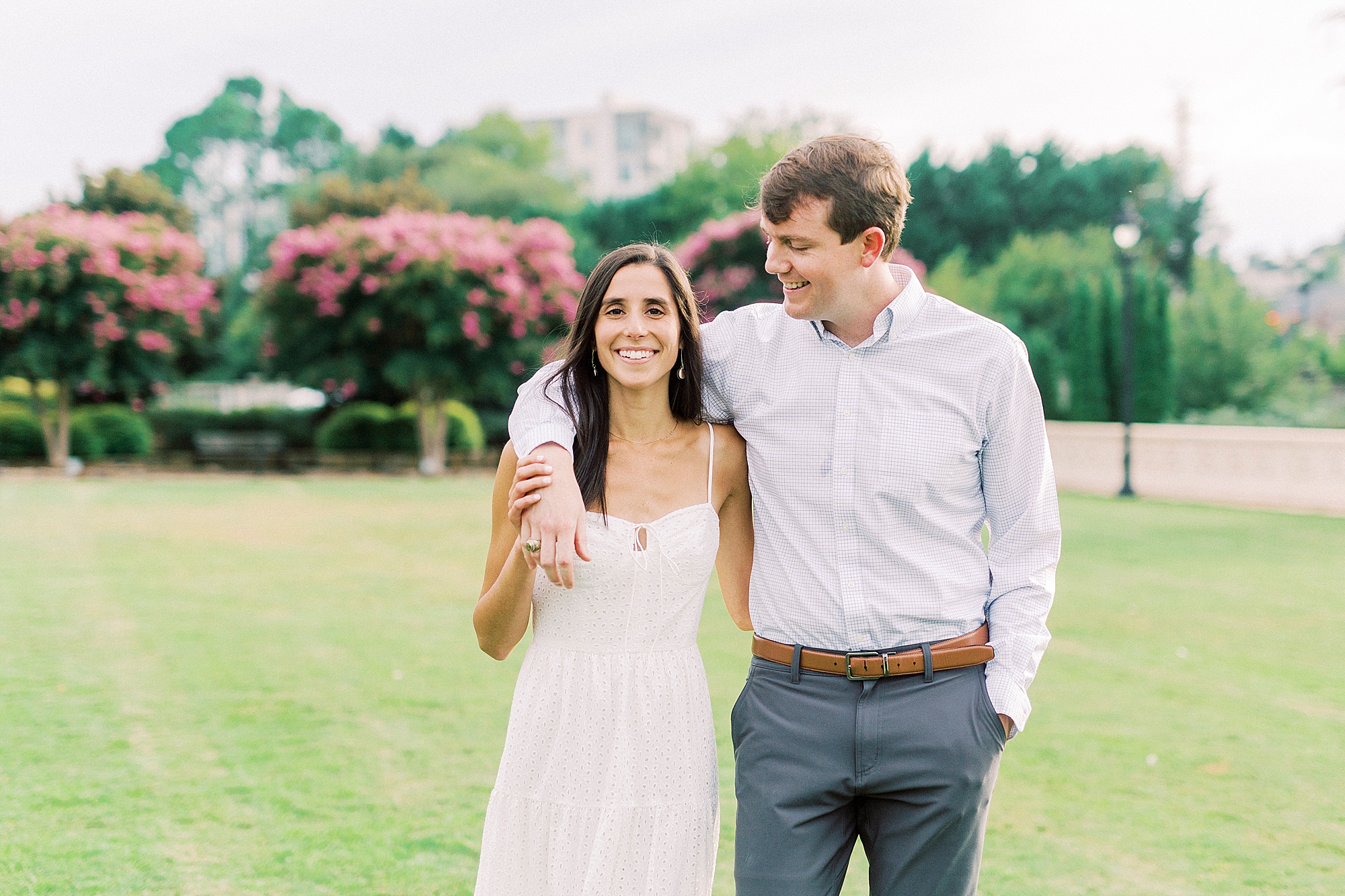 bride and groom walk through Midtown Park with groom holding bride's shoulders