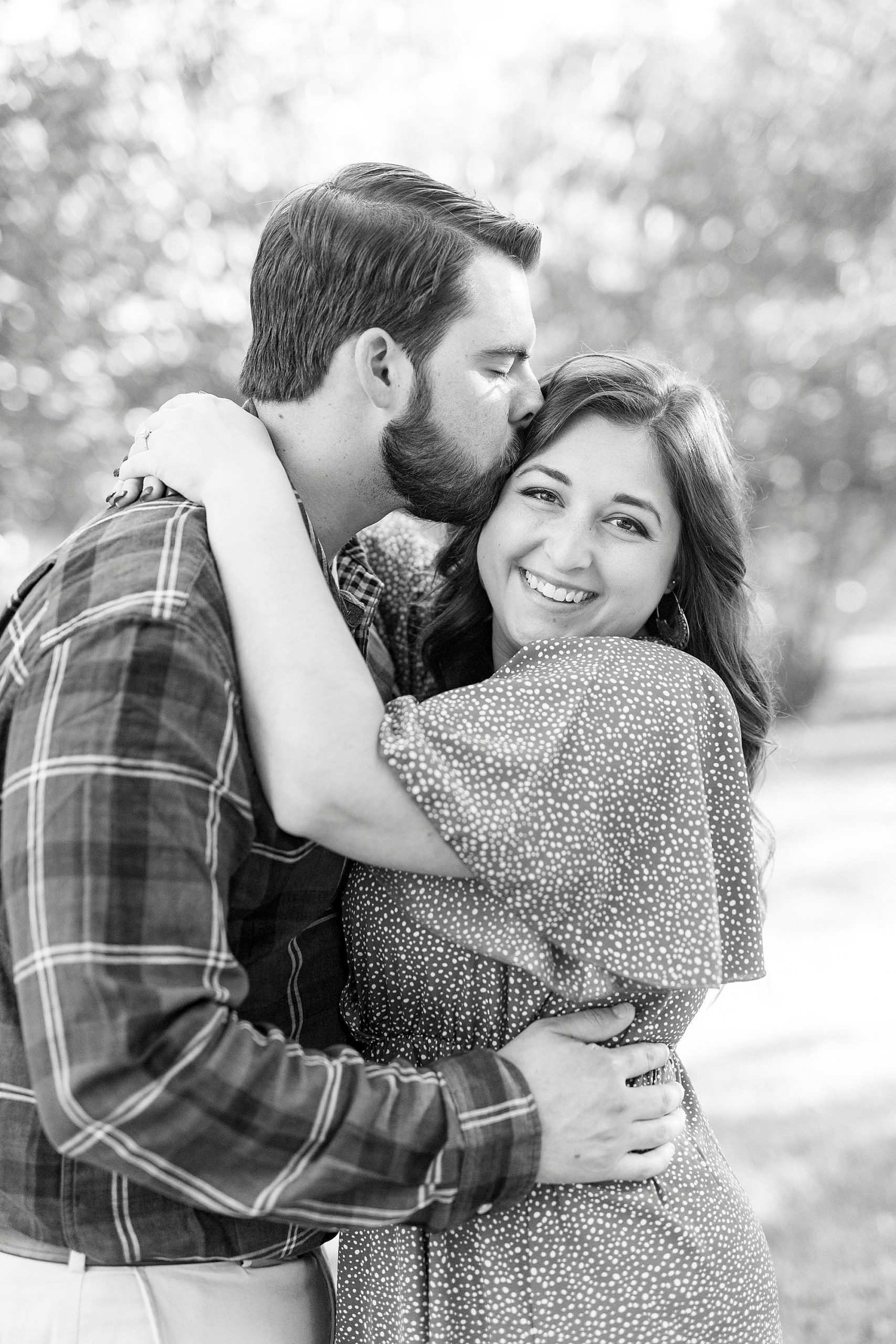 groom kisses bride's forehead during Sloan Park engagement session