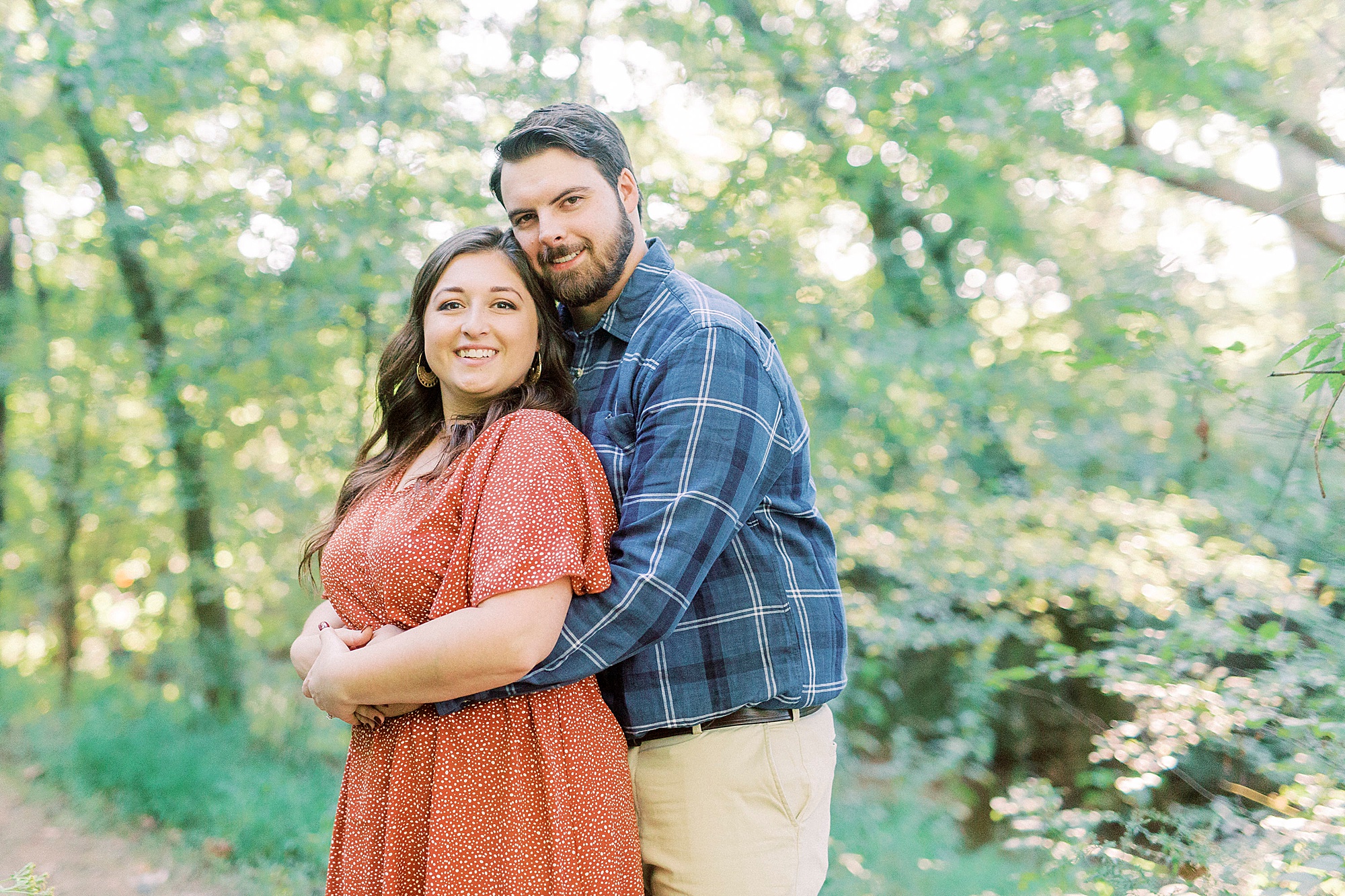 groom hugs bride in woods at Sloan Park