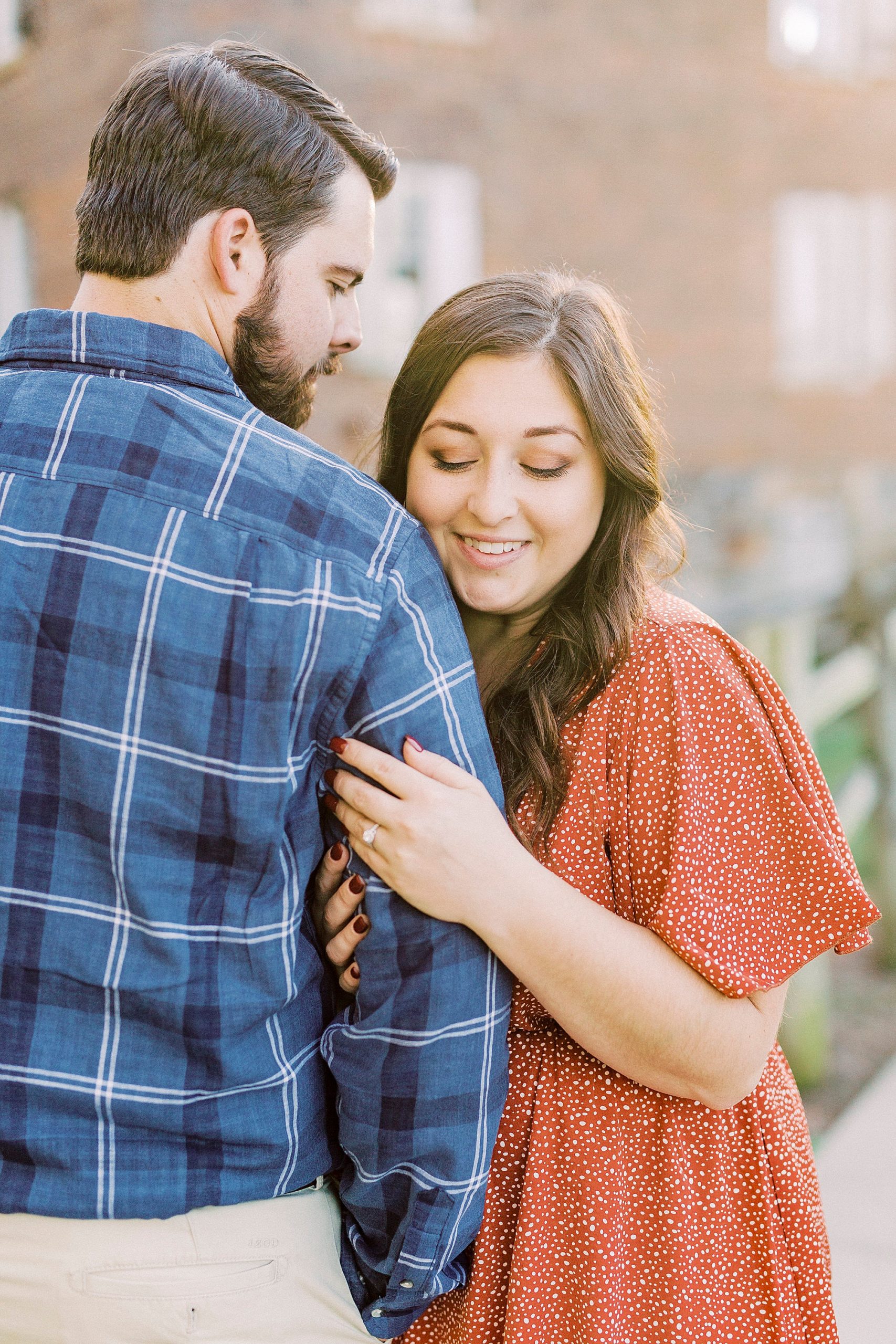 bride looks down at ring during engagement session at Sloan Park