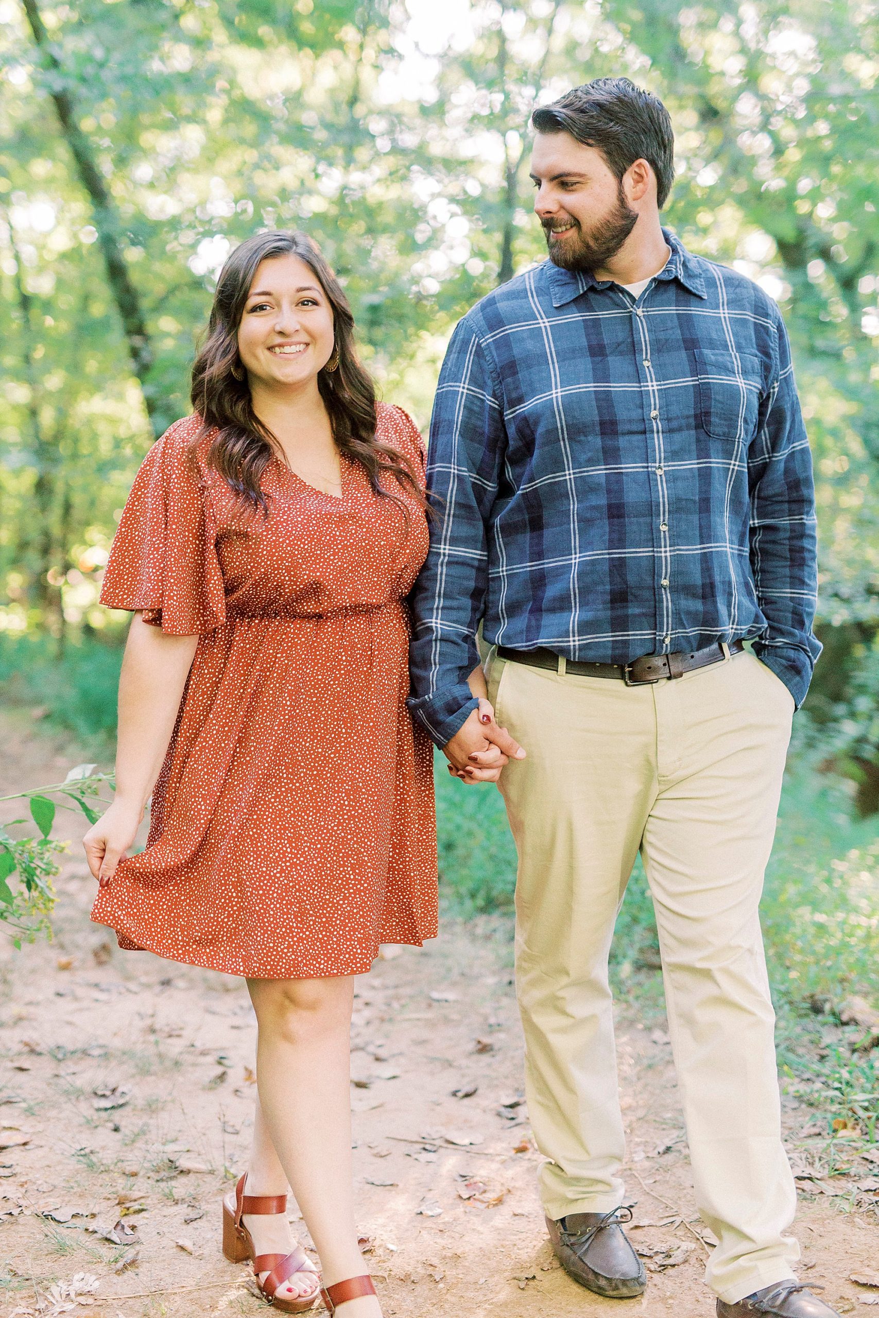 bride and groom hold hands walk through Sloan Park during engagement session