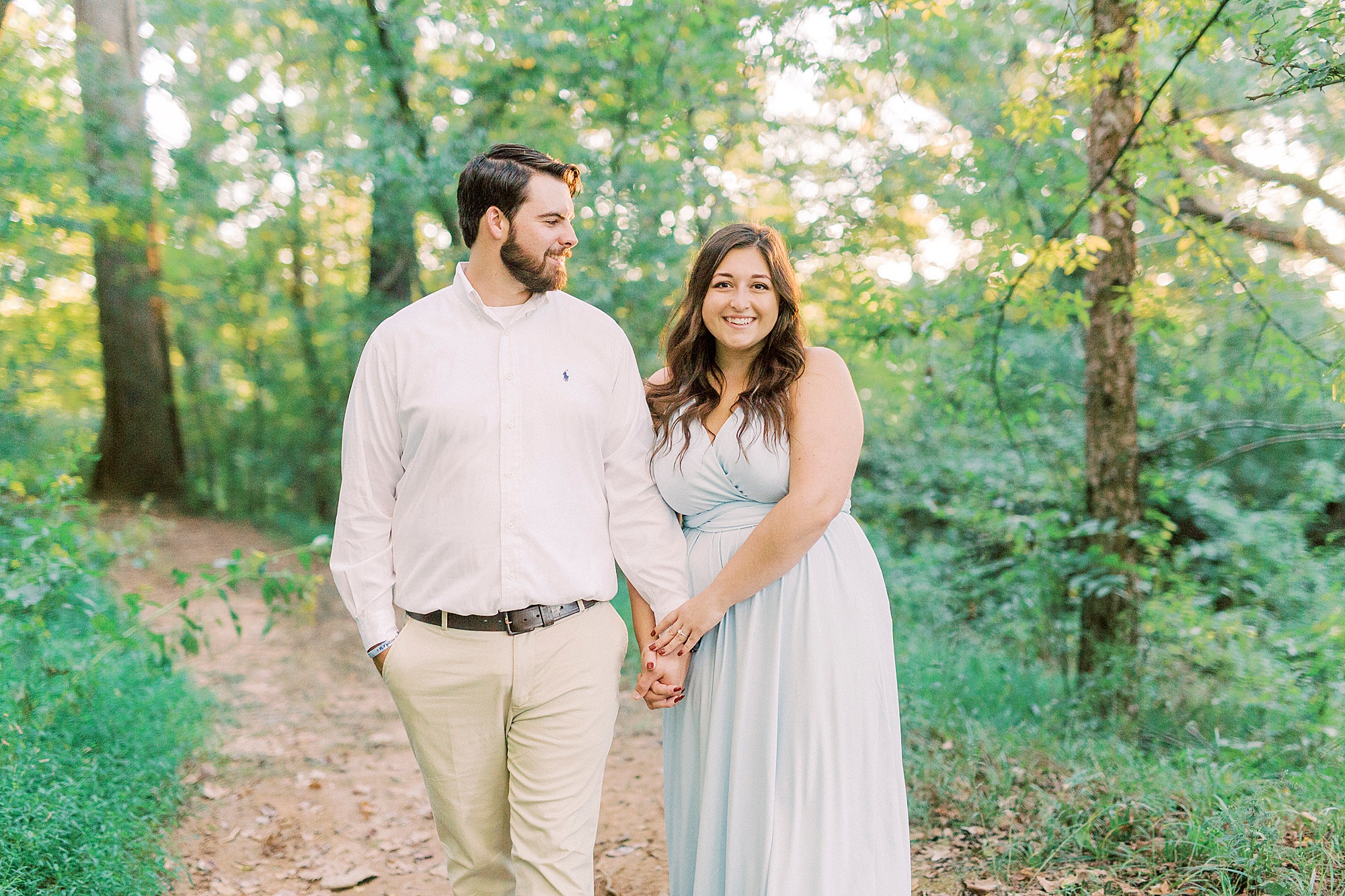bride and groom hold hands walking through park in NC