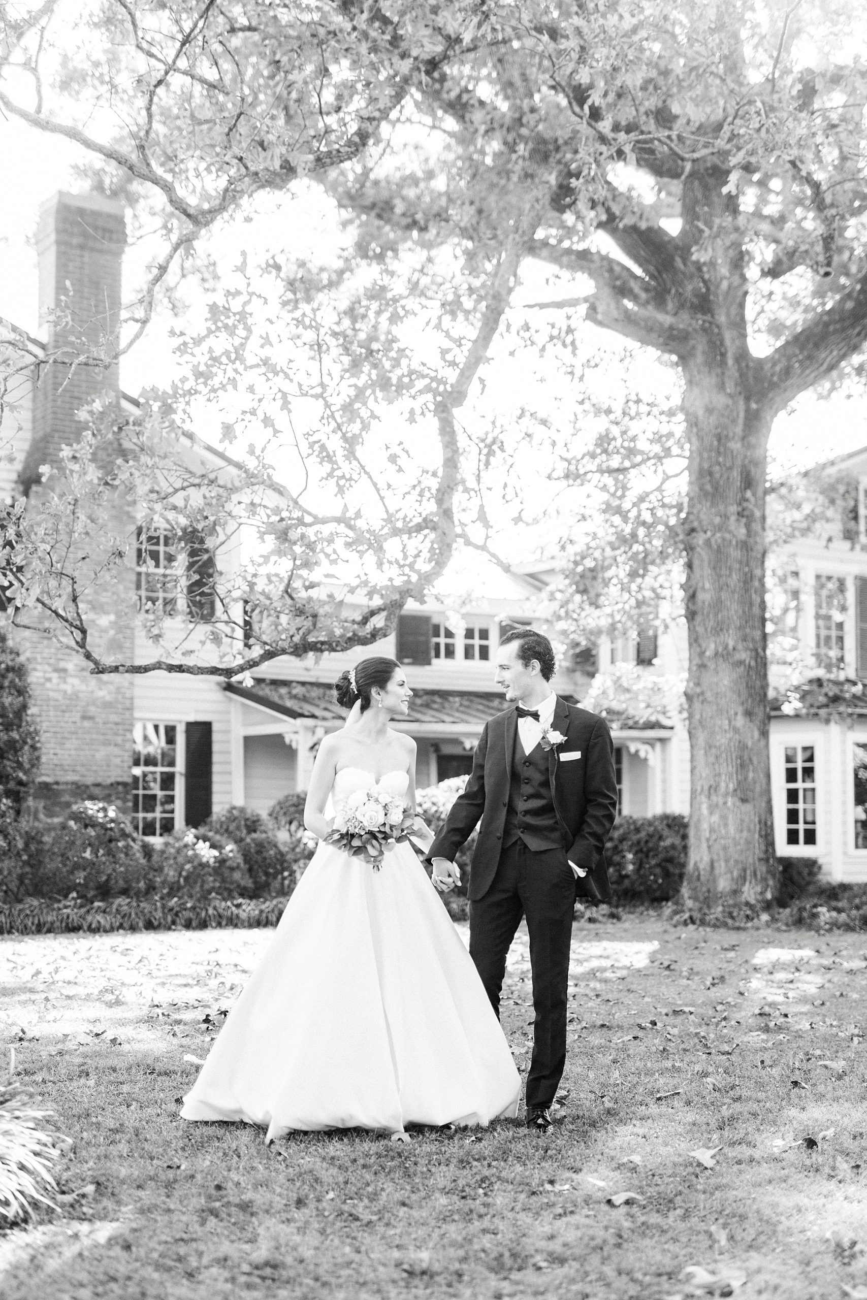 bride and groom hold hands walking on the lawn at 1812 Hitching Post