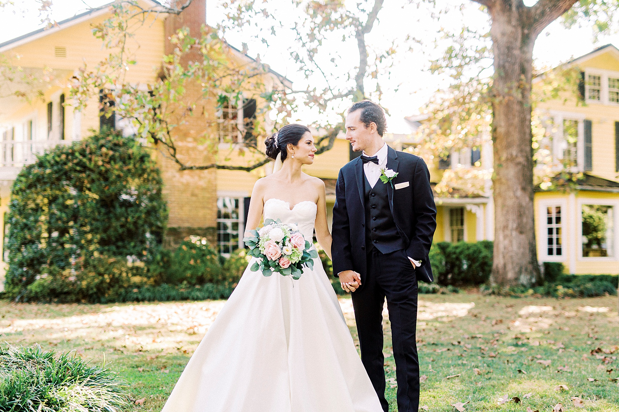 bride nd groom hold hands walking on lawn at 1812 Hitching Post