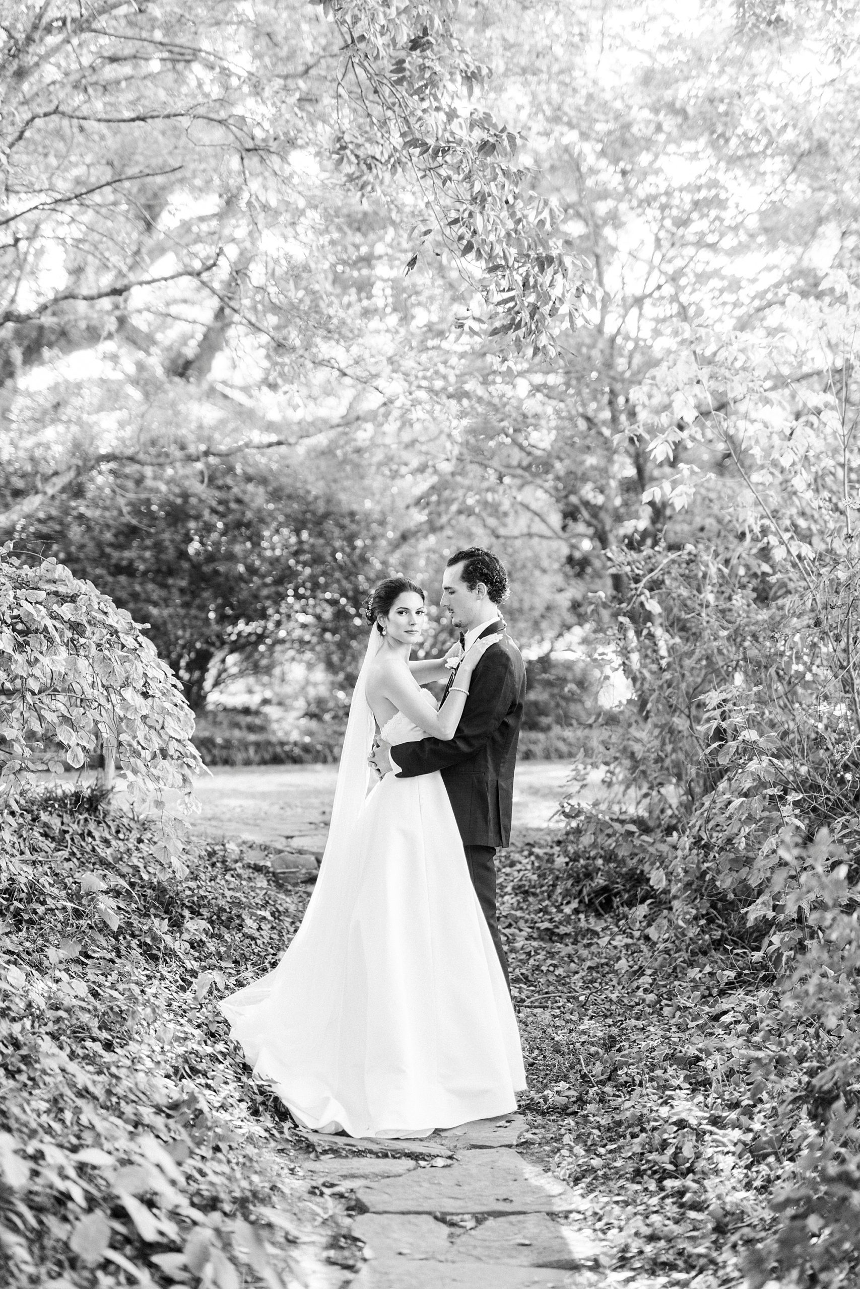 bride and groom stand together in gardens at the 1812 Hitching Post