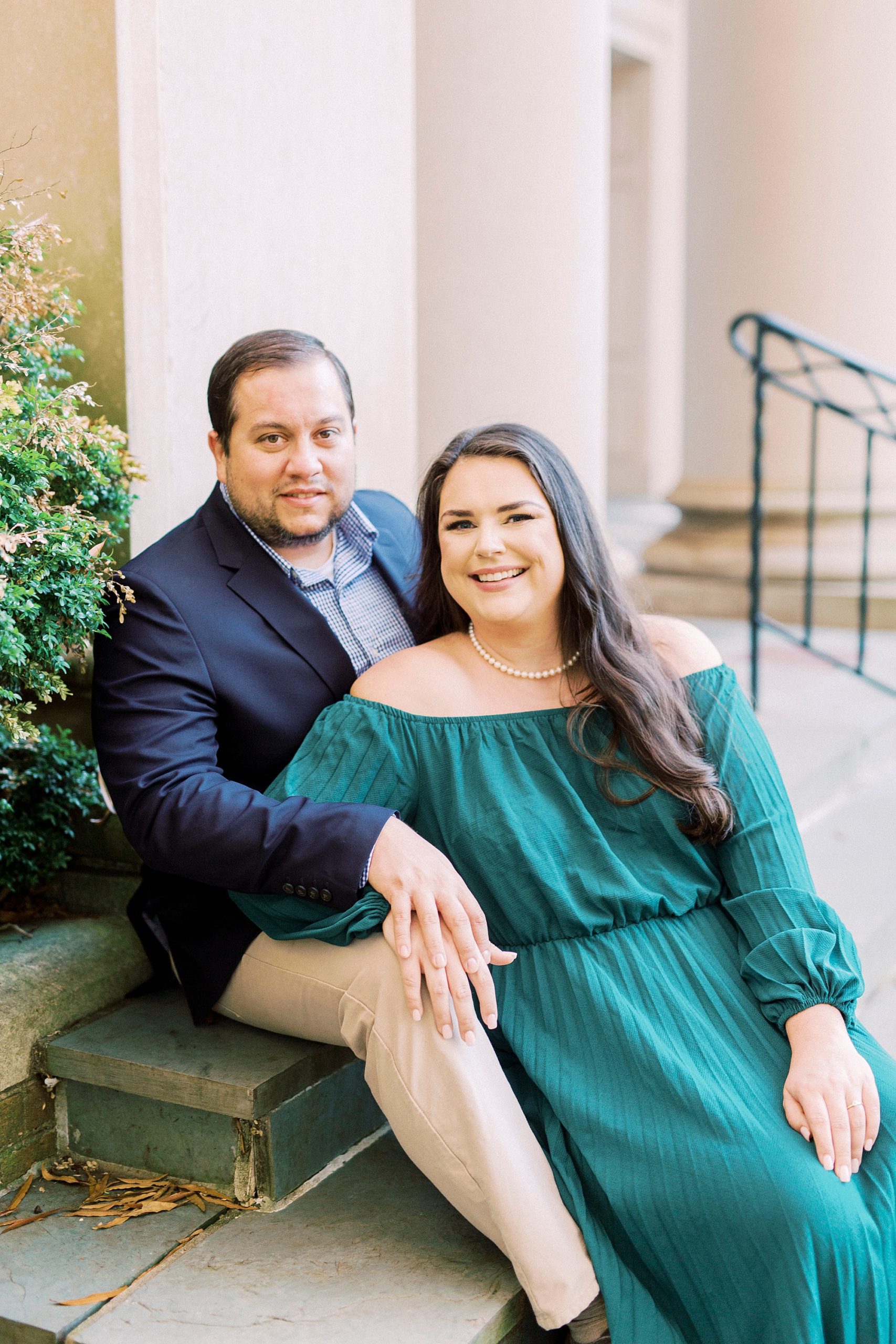 engaged couple sits on steps of Downtown Davidson building
