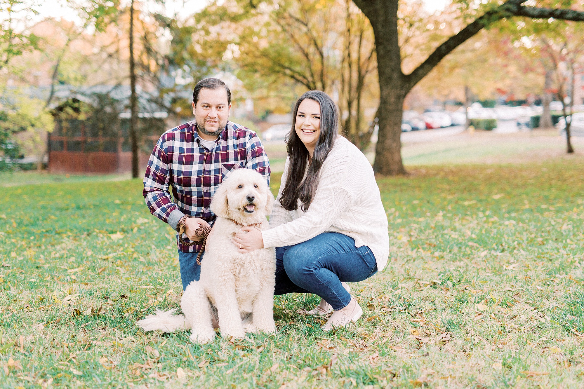 bride and groom pose with dog on lawn in Downtown Davidson