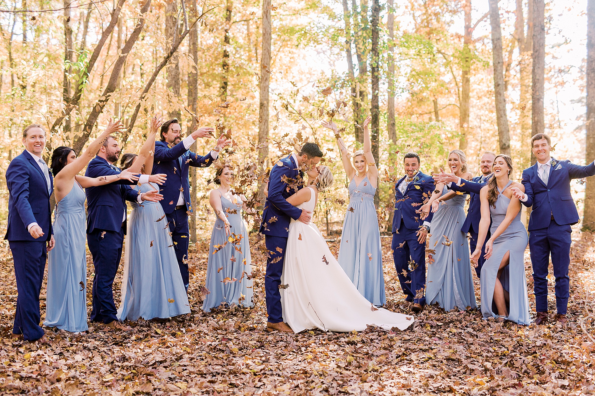 couple kisses while leaves fall around them