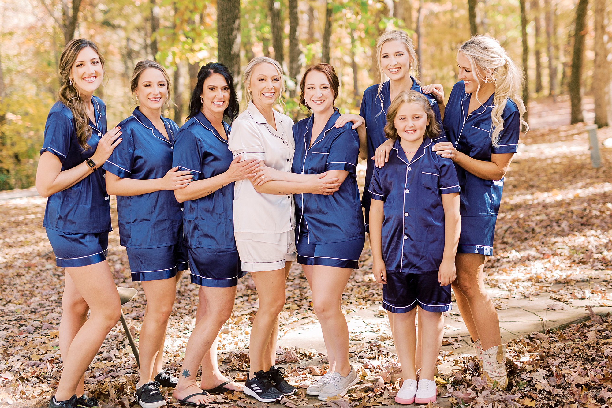 bride poses with bridesmaids in navy pajama sets