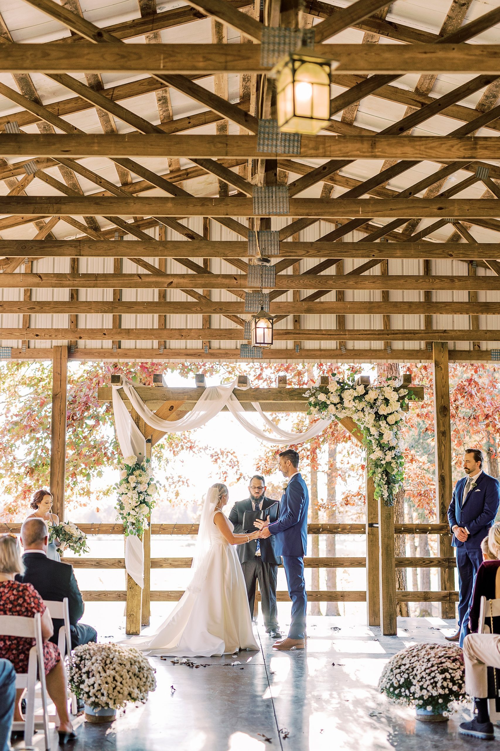 newlyweds hold hands during fall wedding ceremony