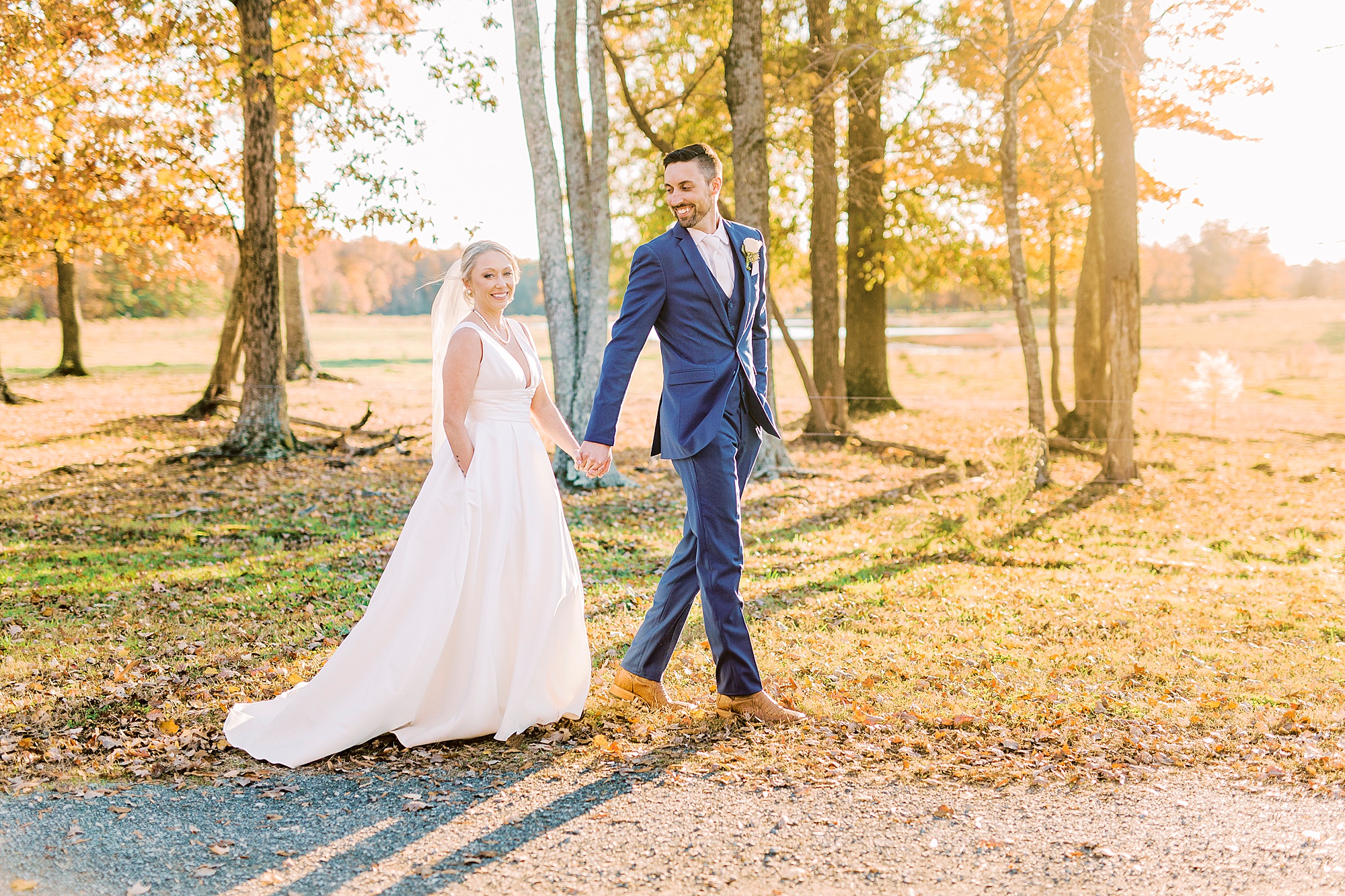 bride and groom hold hands walking through woods at the Farm at Brusharbor