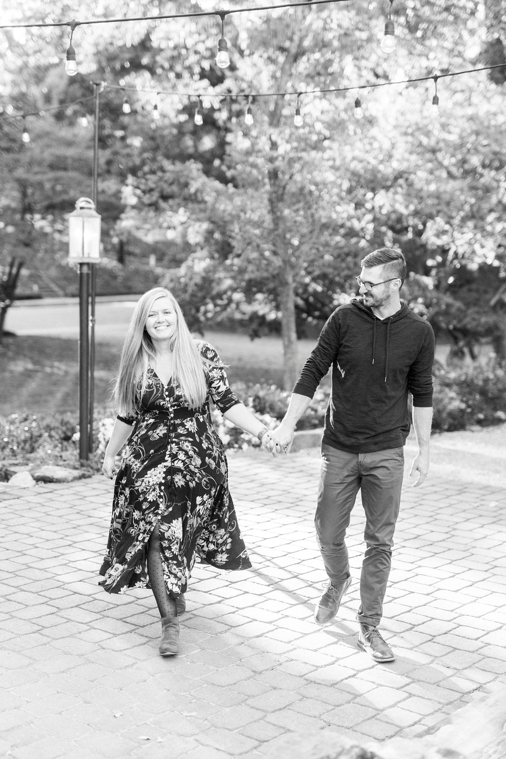 couple holds hands walking on patio at Ritchie Hill