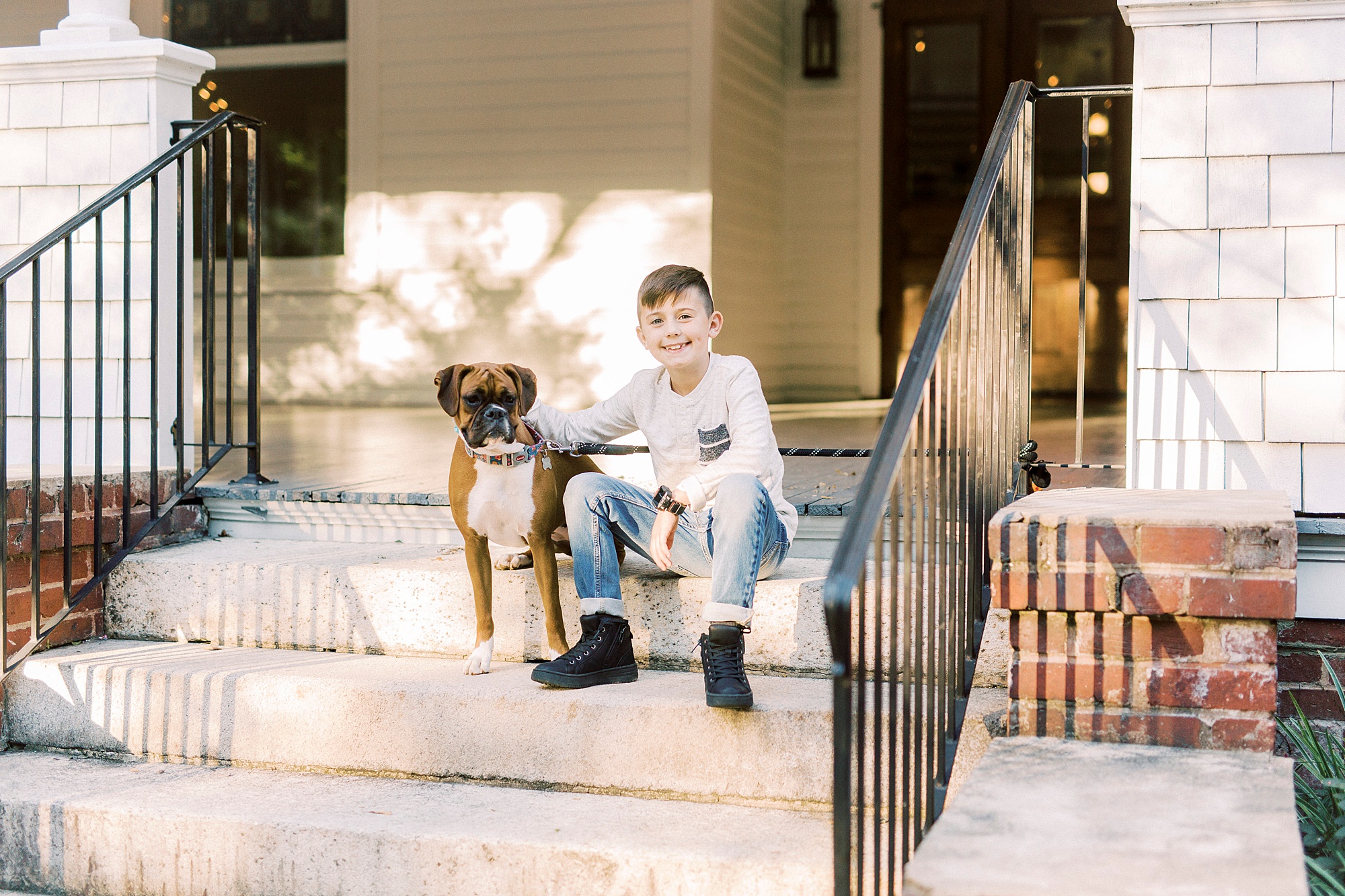 boy sits on front step with dog at Ritchie Hill