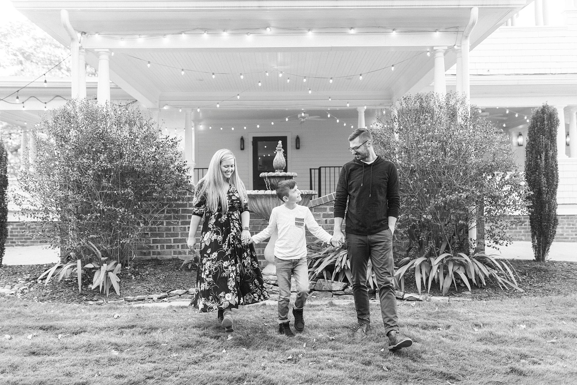 couple holds son's hands walking by Ritchie Hill
