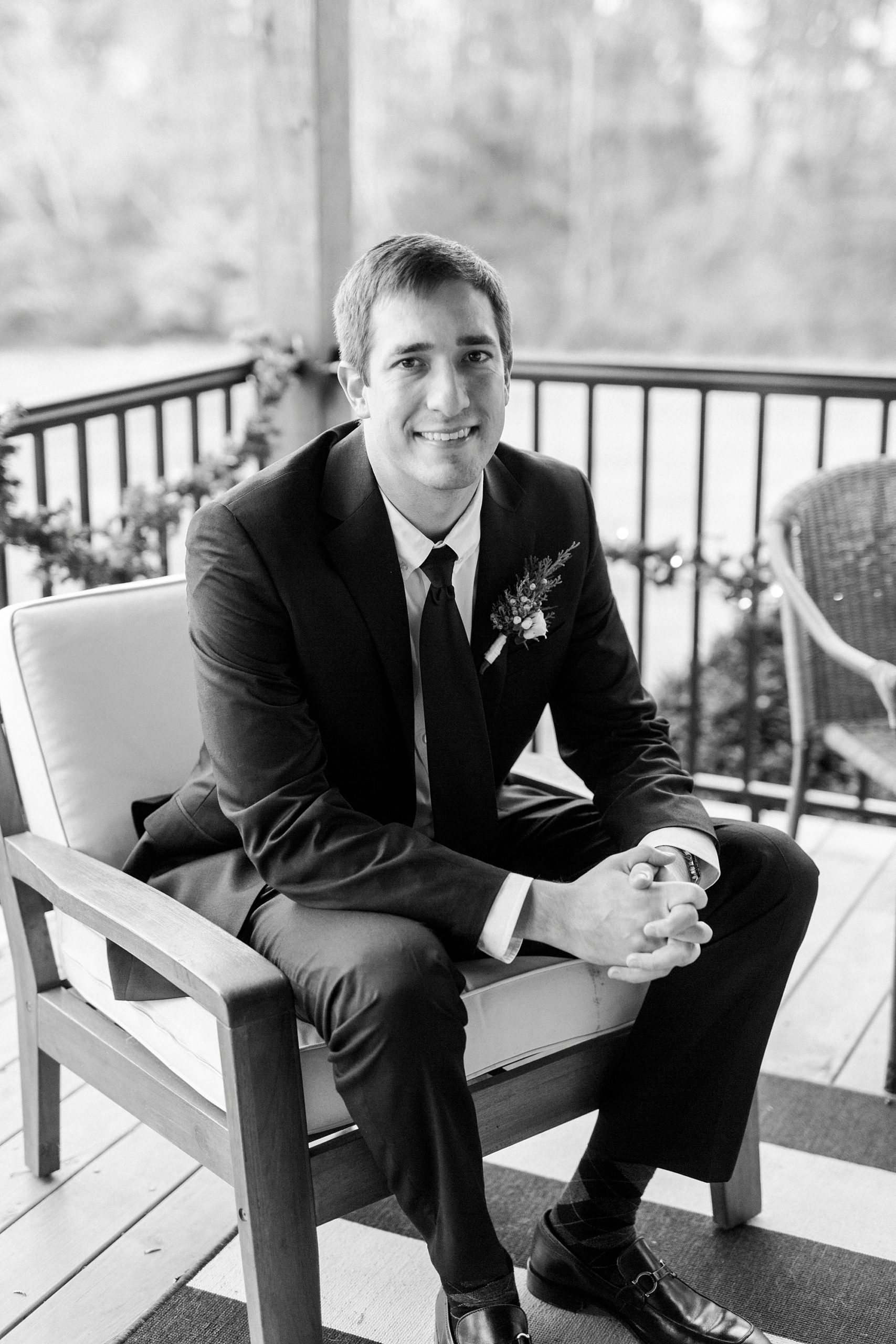 groom sits on back porch before romantic winter wedding in Bedford VA