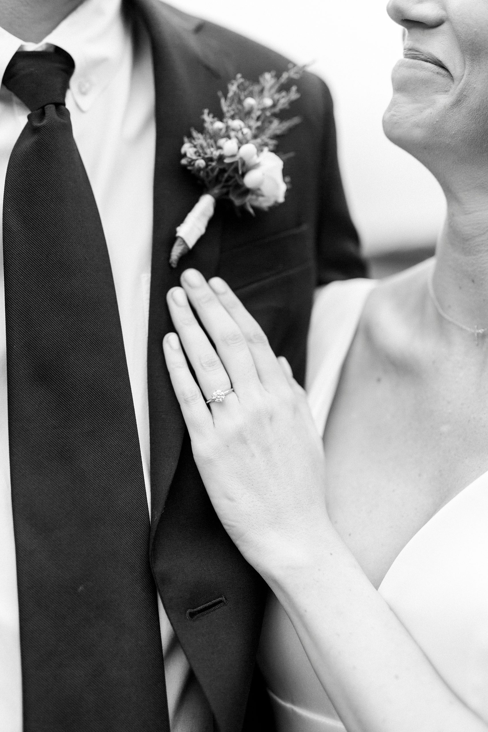 bride lays hand on groom's chest during portraits
