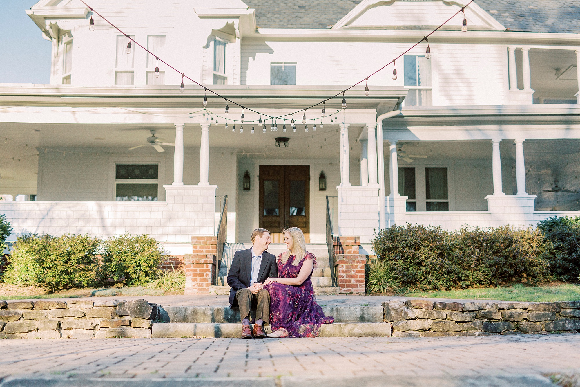 engaged couple sits on patio at Ritchie Hill