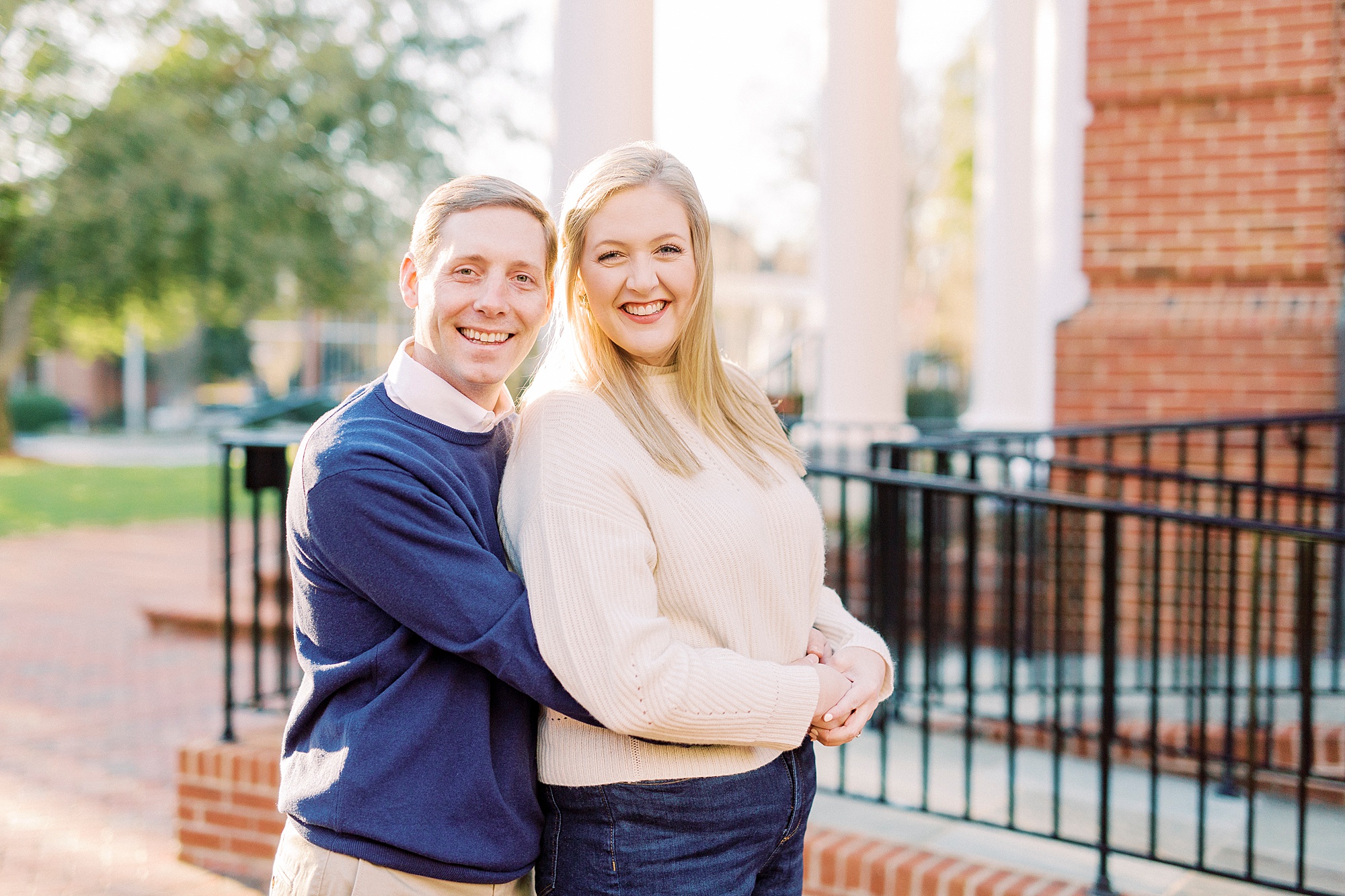 groom hugs bride from behind during Downtown Concord engagement photos