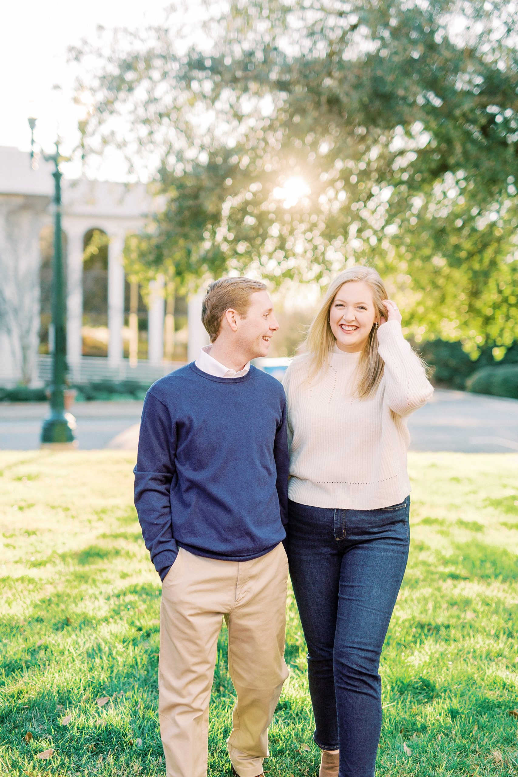 bride smiles pushing her hair behind her ear during fall Downtown Concord engagement photos