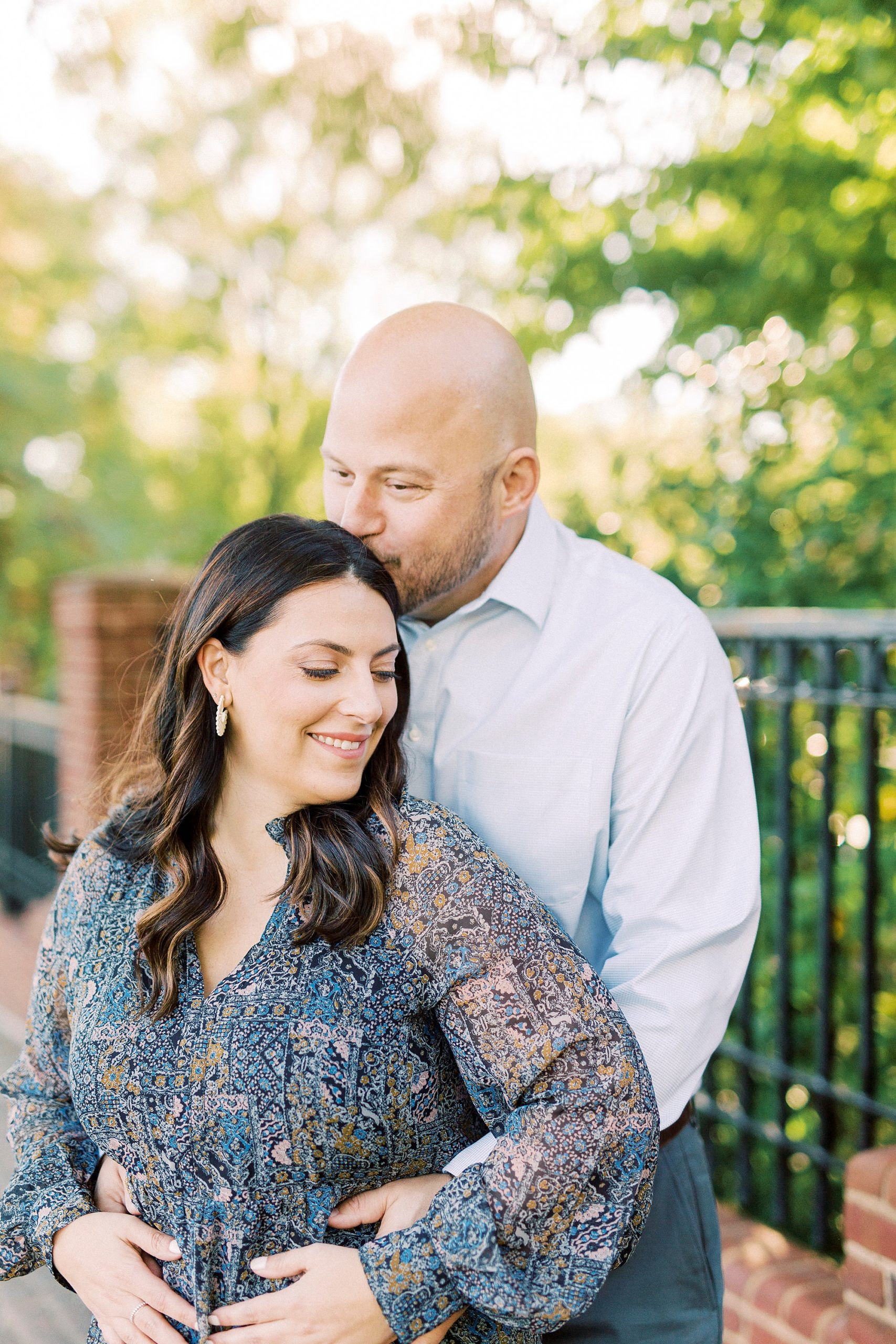 groom kisses bride's forehead during Downtown Matthews engagement session