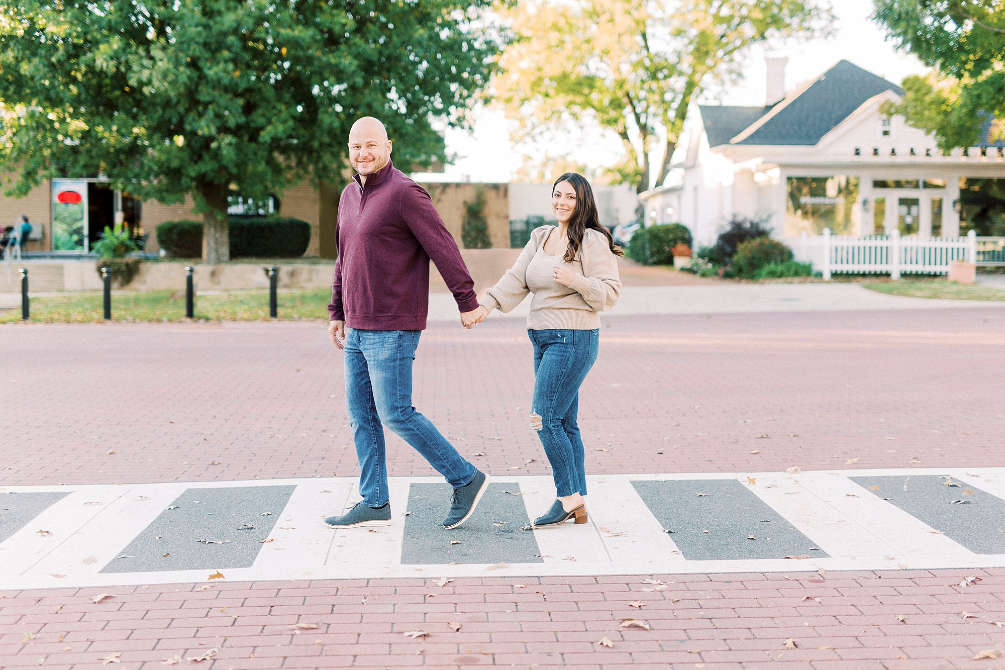 groom leads bride across crosswalk in Downtown Matthews