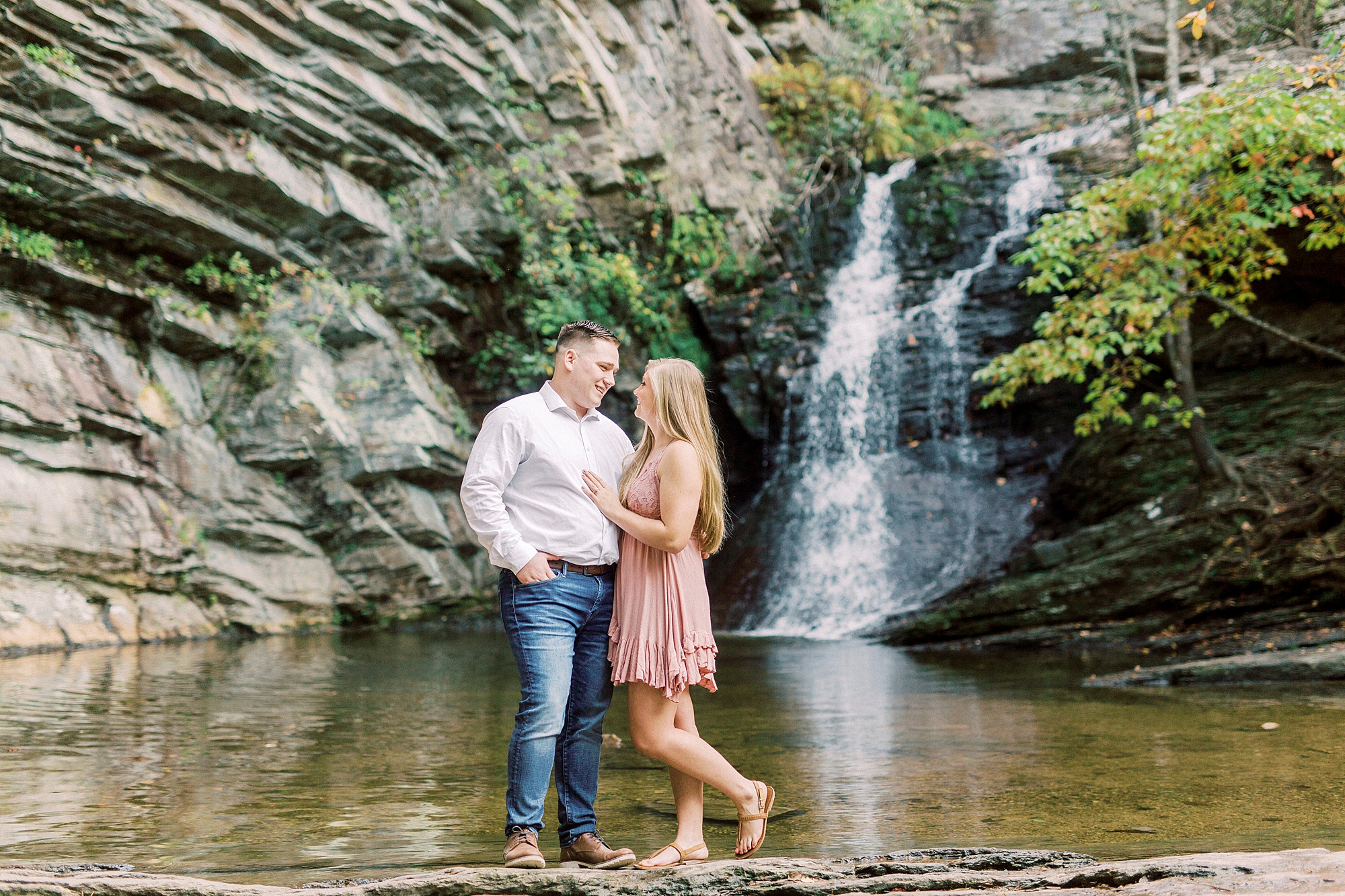 couple poses by lower Cascades in Hanging Rock State Park