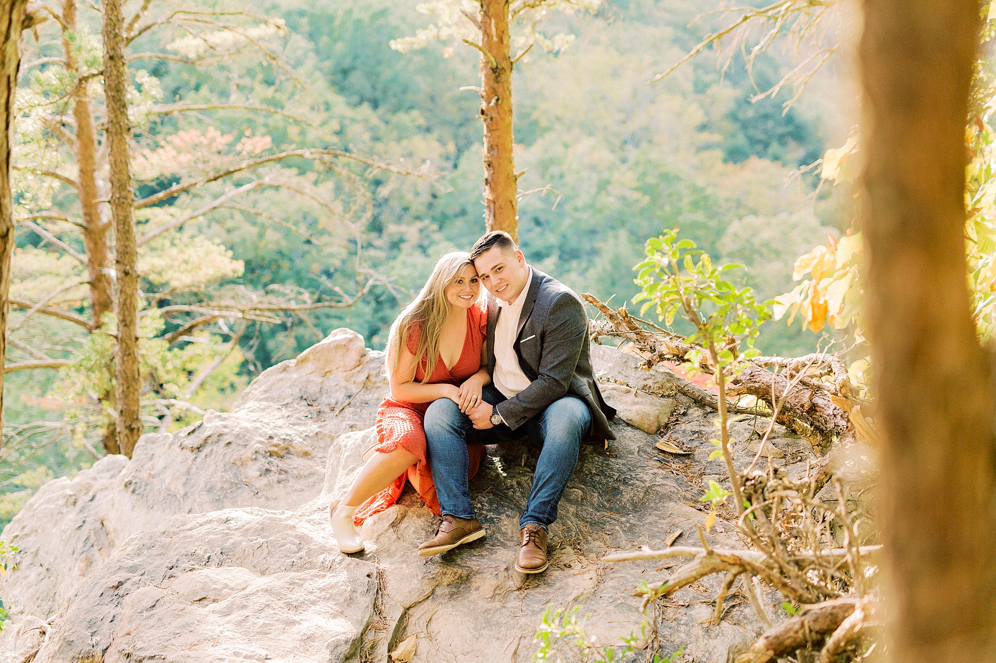 couple sits on rocks at the top of hike in Hanging Rock State Park