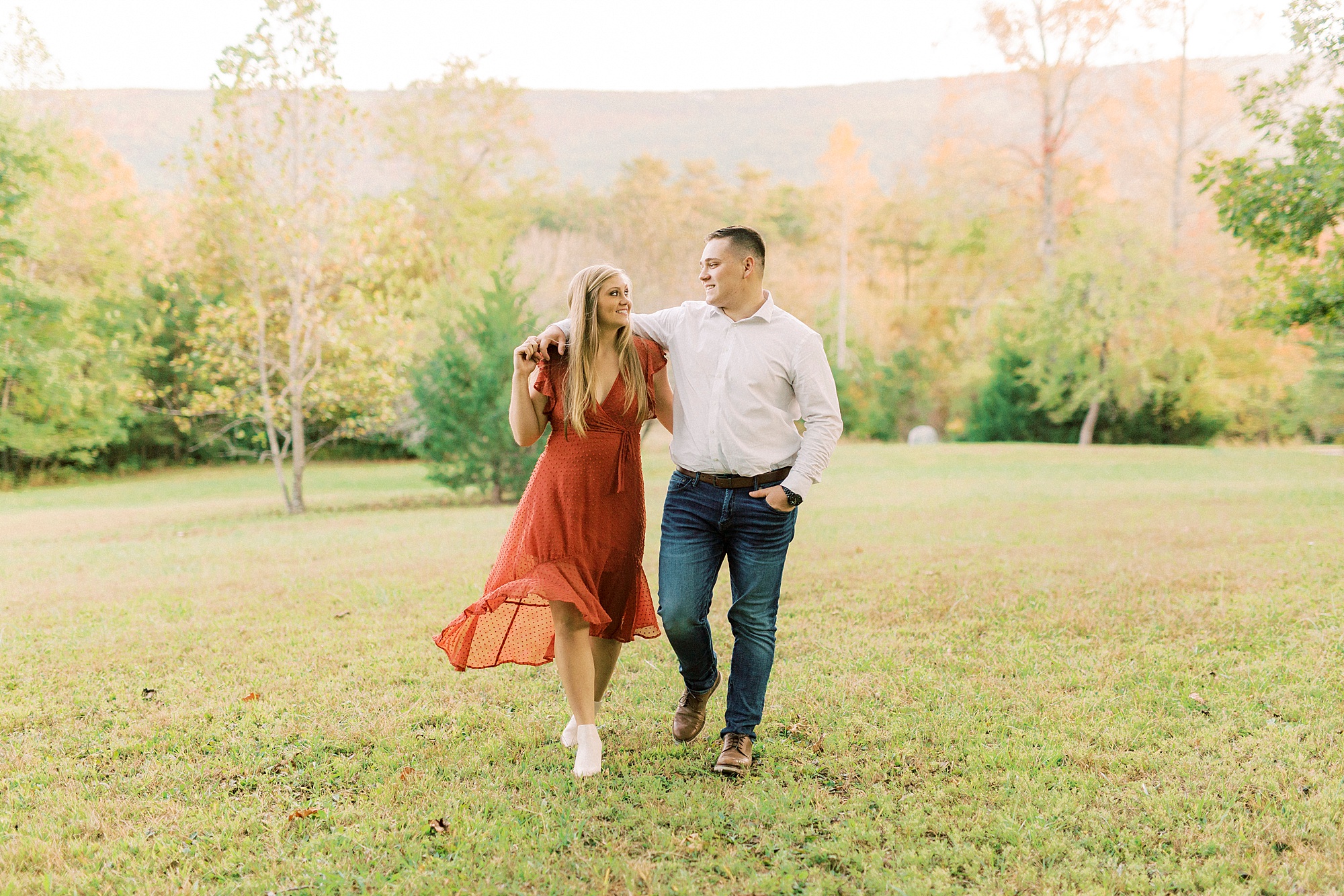 couple walks together through field