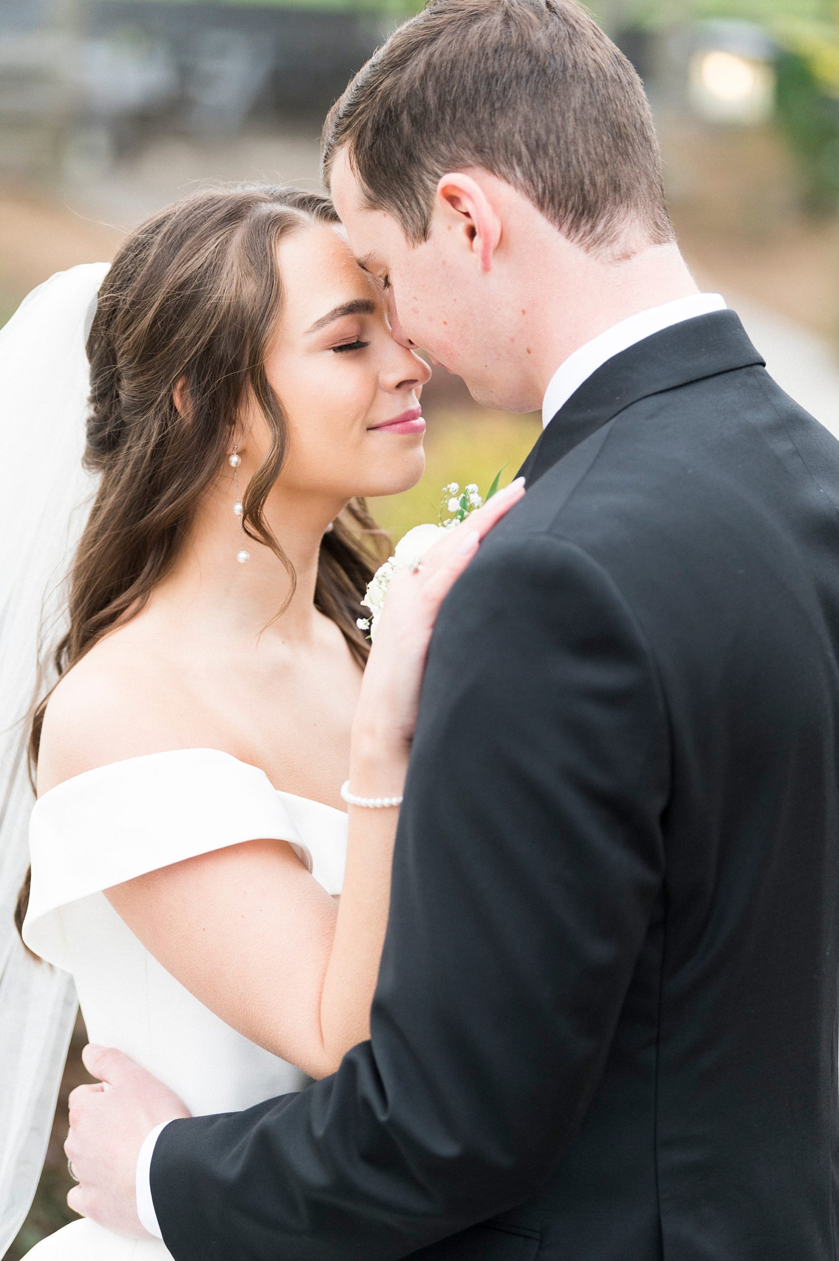 bride and groom stand with noses touching