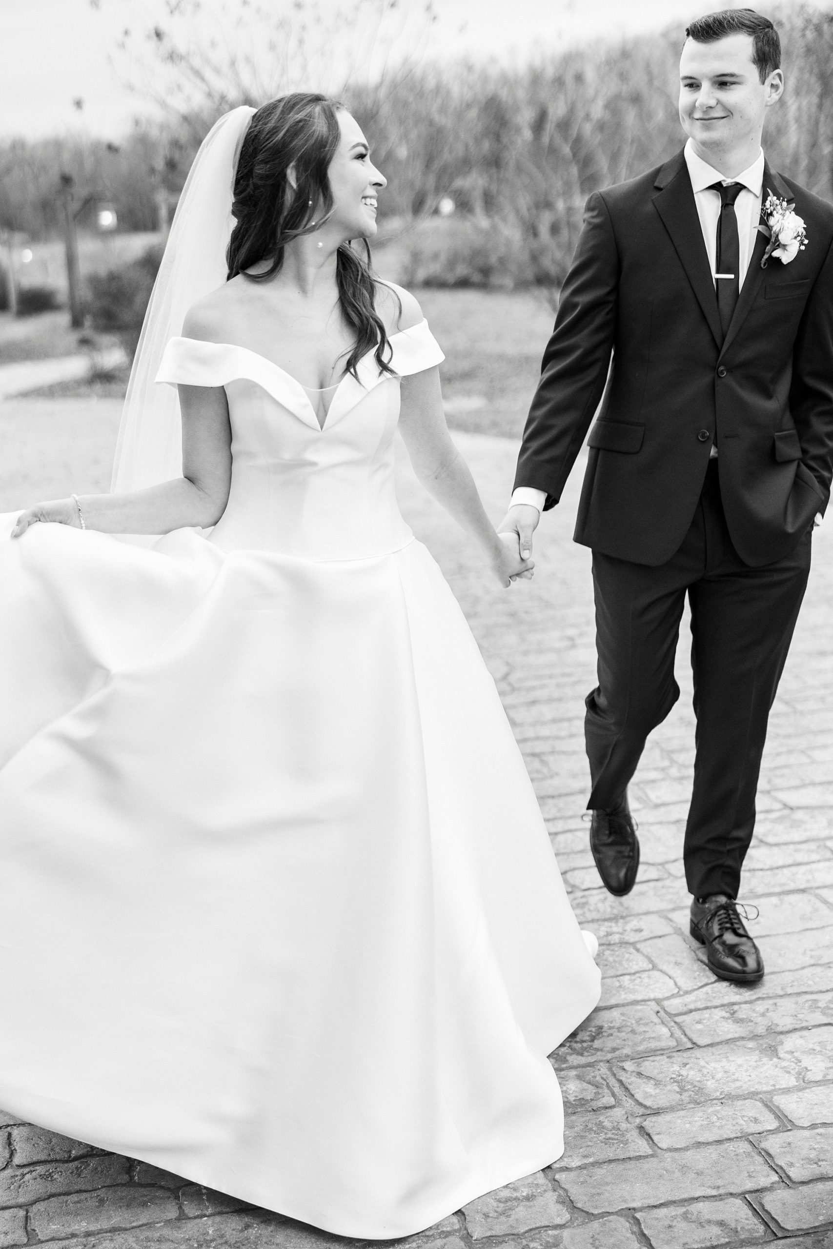 couple holds hands walking through patio at The Farm at Brusharbor