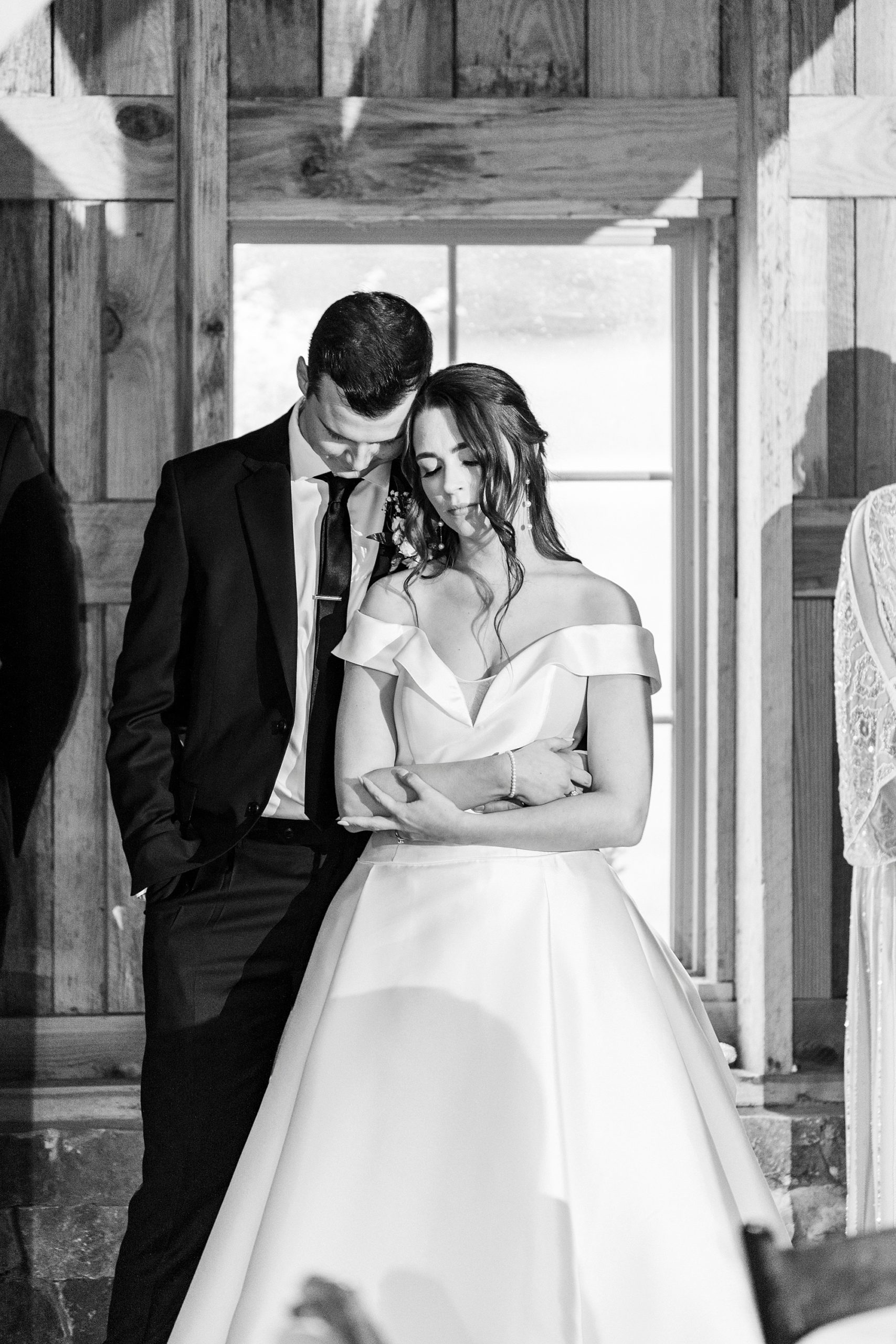newlyweds bow heads together during prayer at NC reception