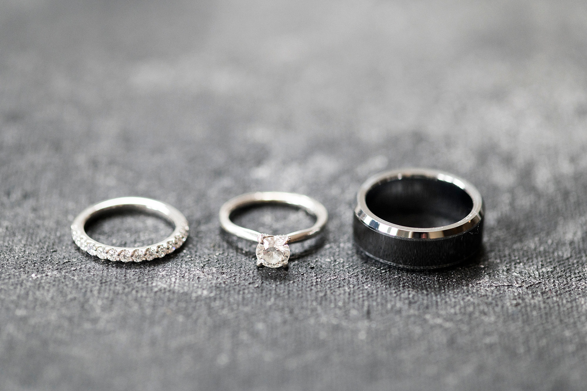 wedding bands lay on grey backdrop