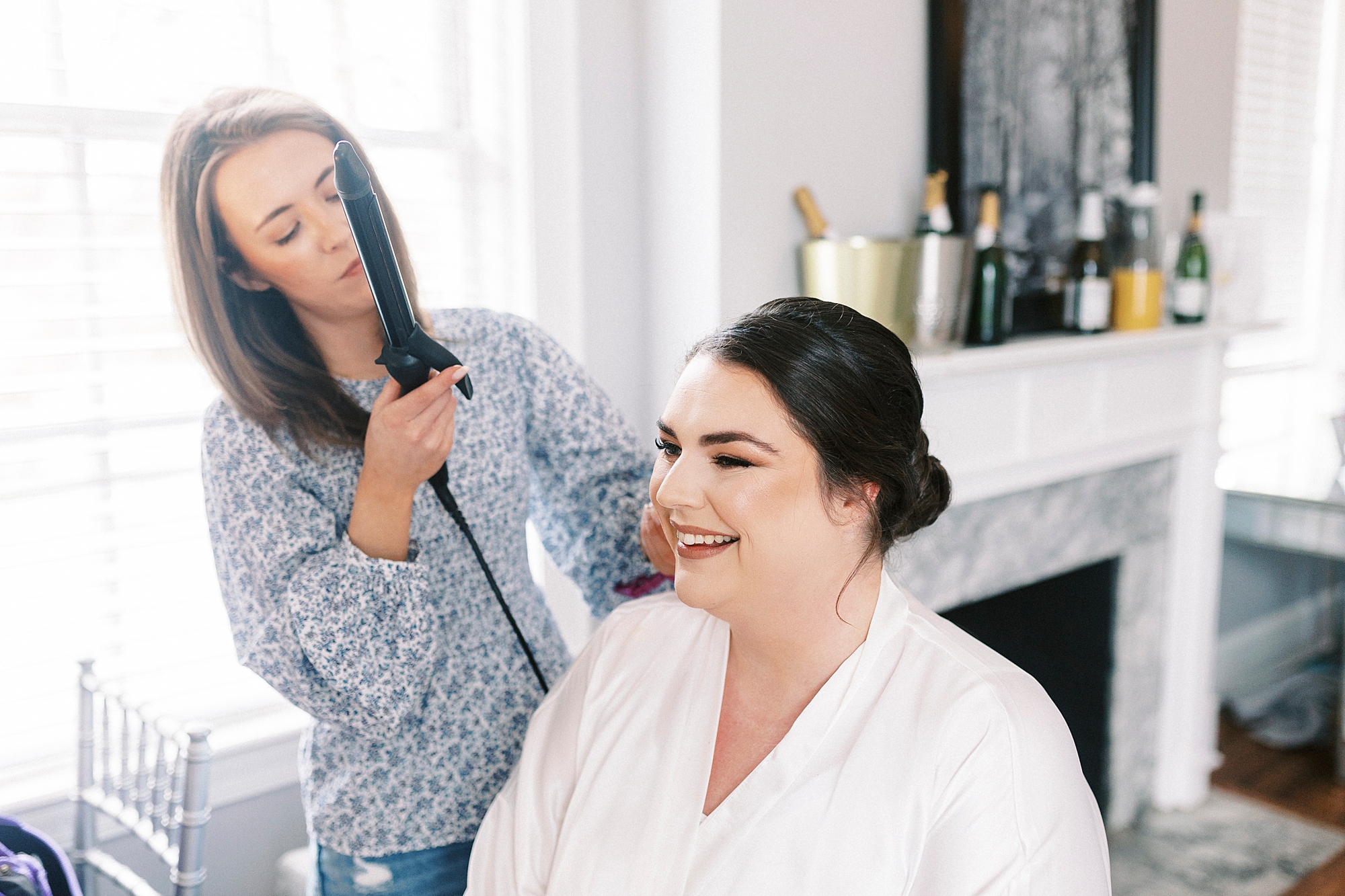 hair stylist helps bride on wedding day
