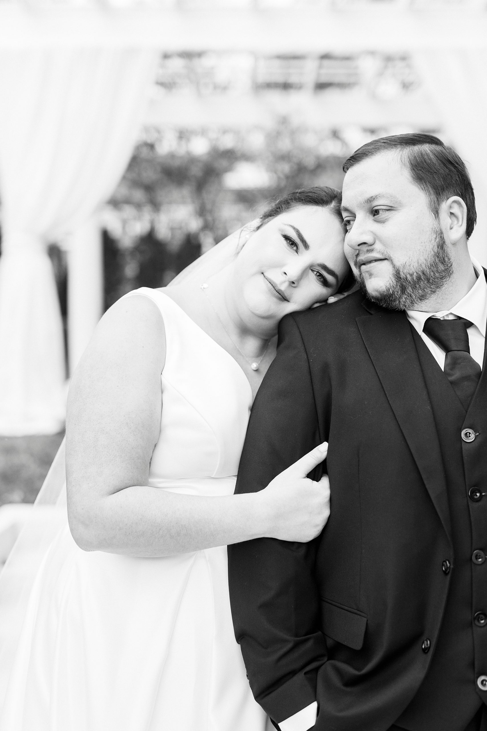 bride leans against groom's arm during portraits by patio at Separk Mansion