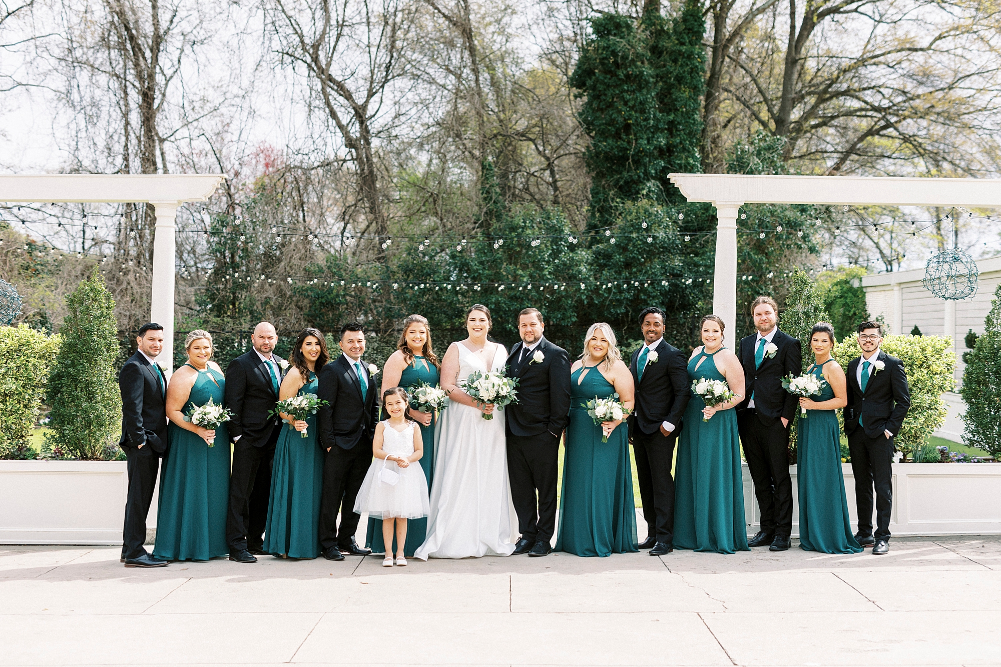 couple poses with wedding party in green and black at Separk Mansion