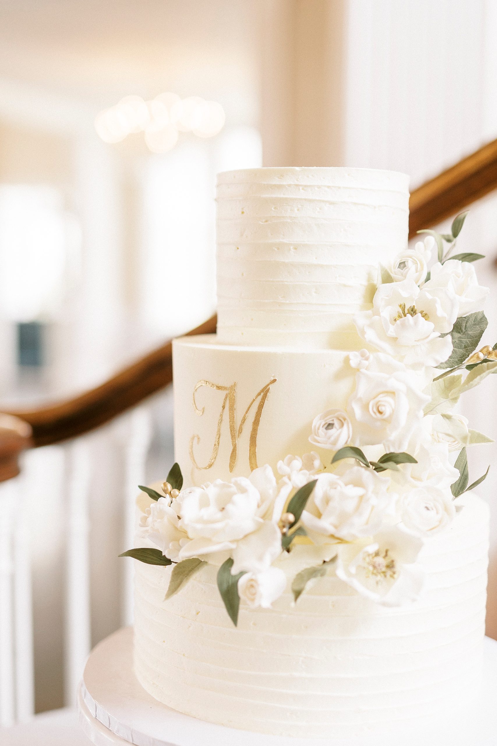 floral details on cake with gold "M" 