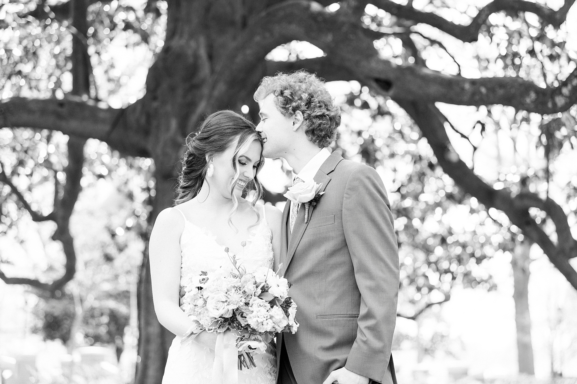 groom kisses bride's head during first look in Raleigh NC