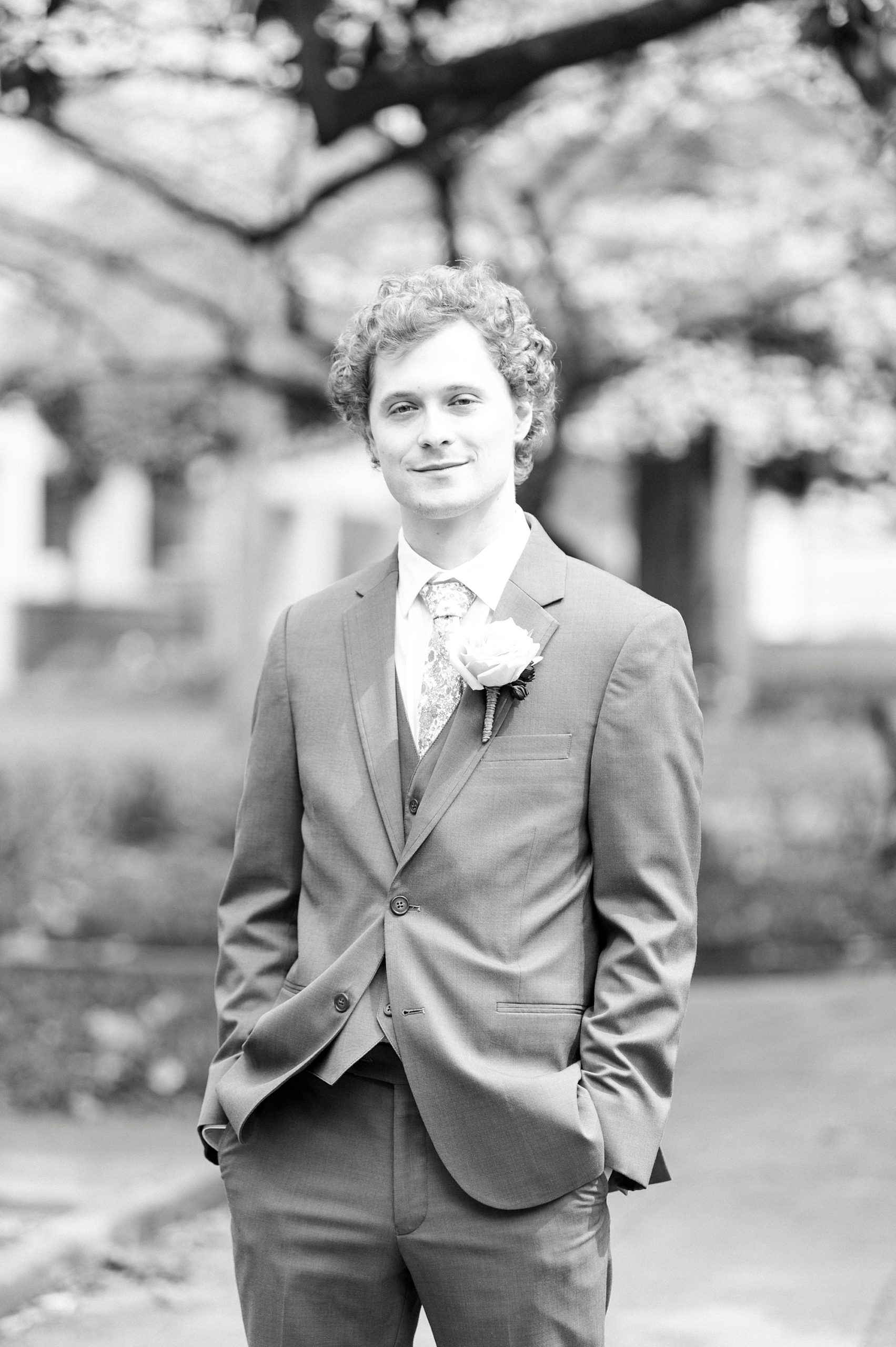 groom stands with hands in pockets during Raleigh NC wedding day