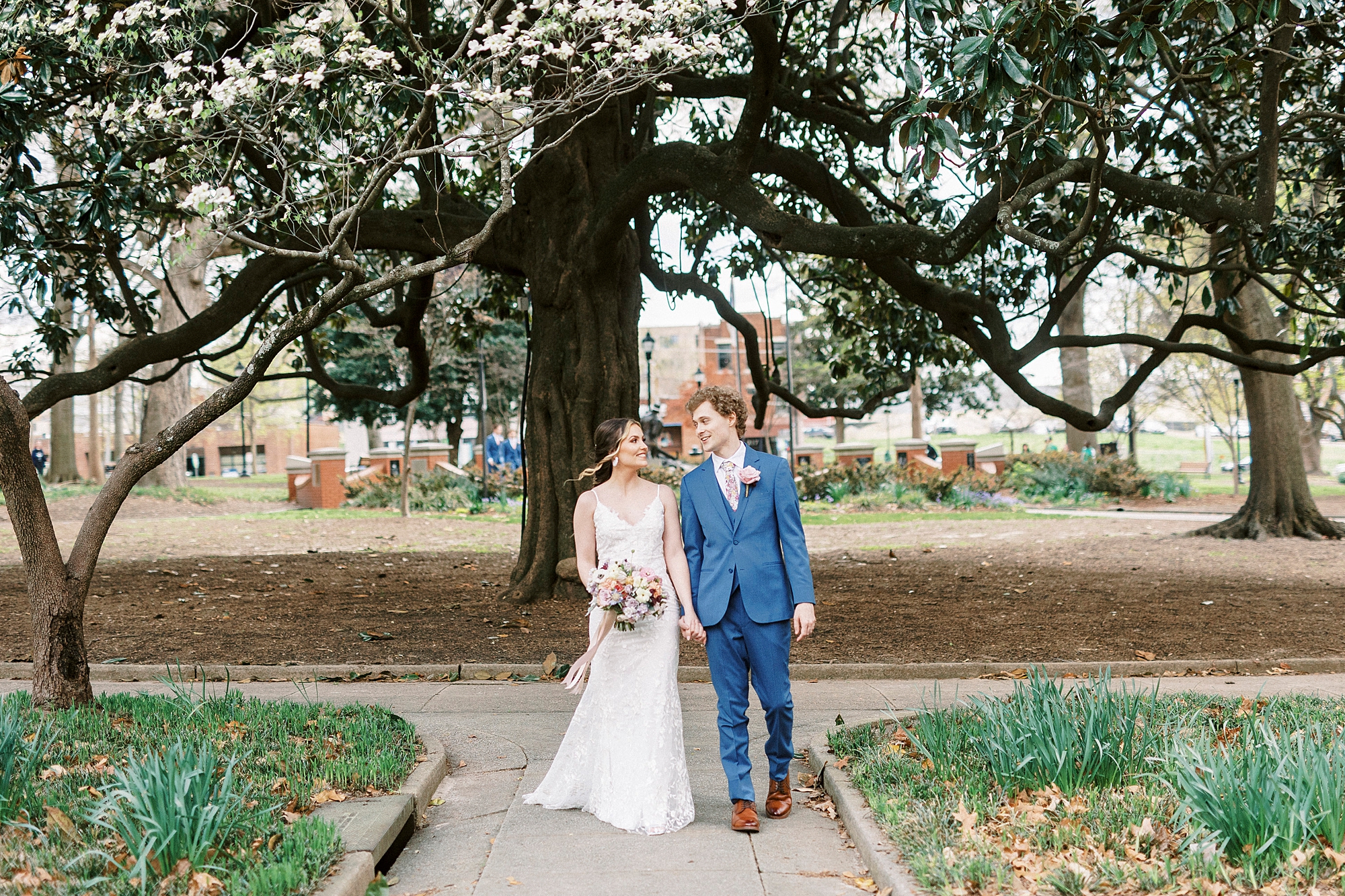bride and groom walk through courtyard outside the Stockroom at 230