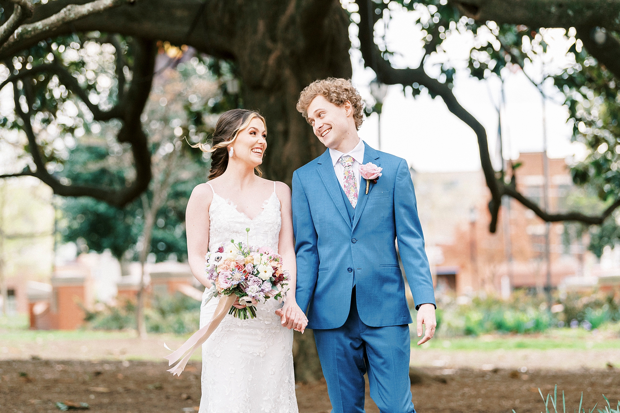 couple holds hands during spring wedding photos