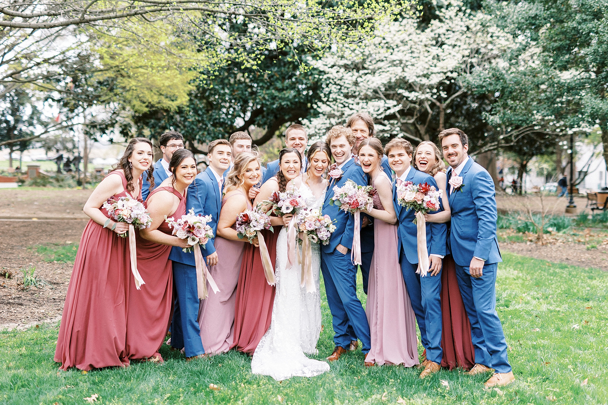 newlyweds pose with wedding party in courtyard at Stockroom at 230