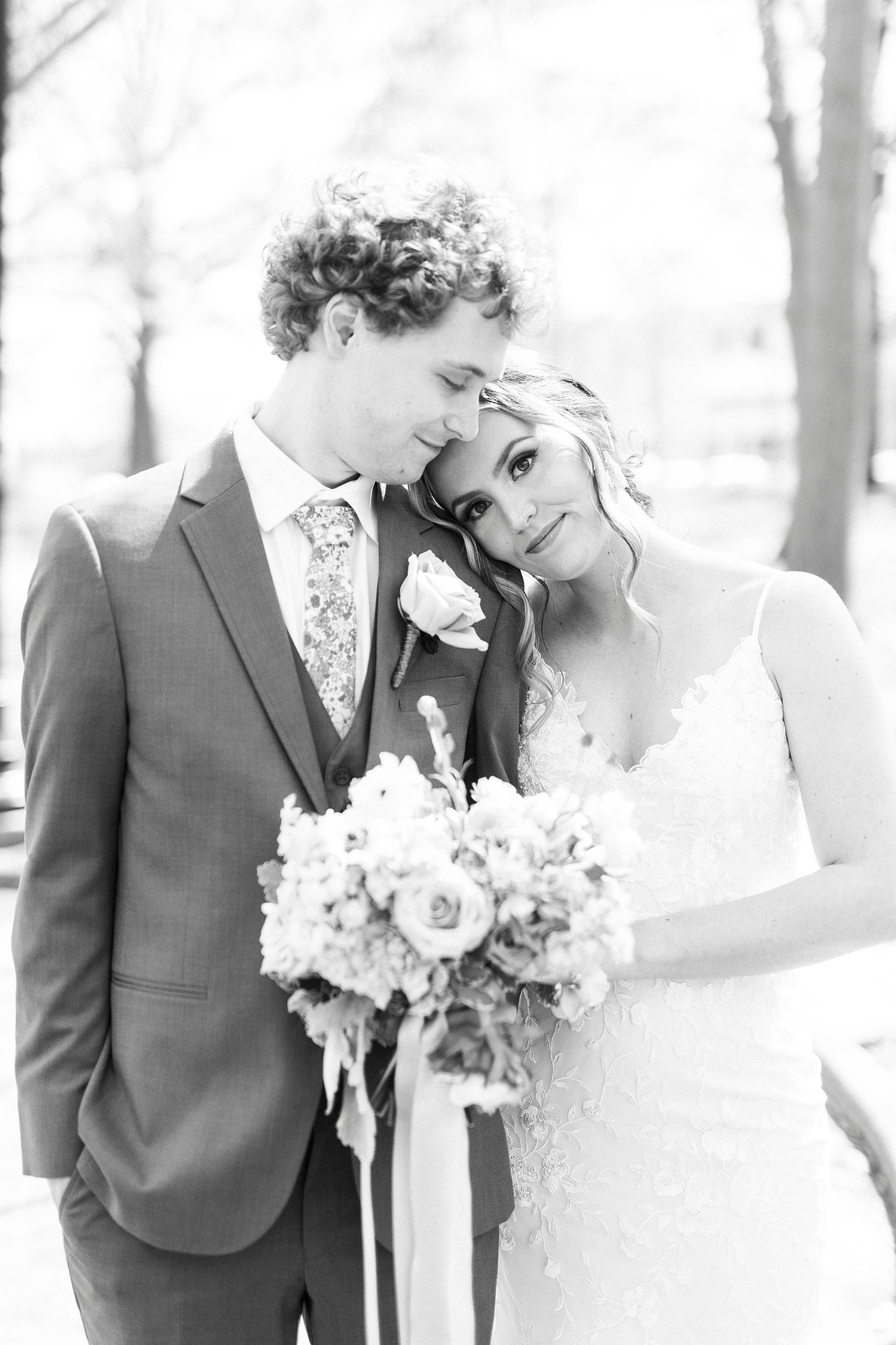 bride leans on groom's shoulder during Raleigh wedding portraits