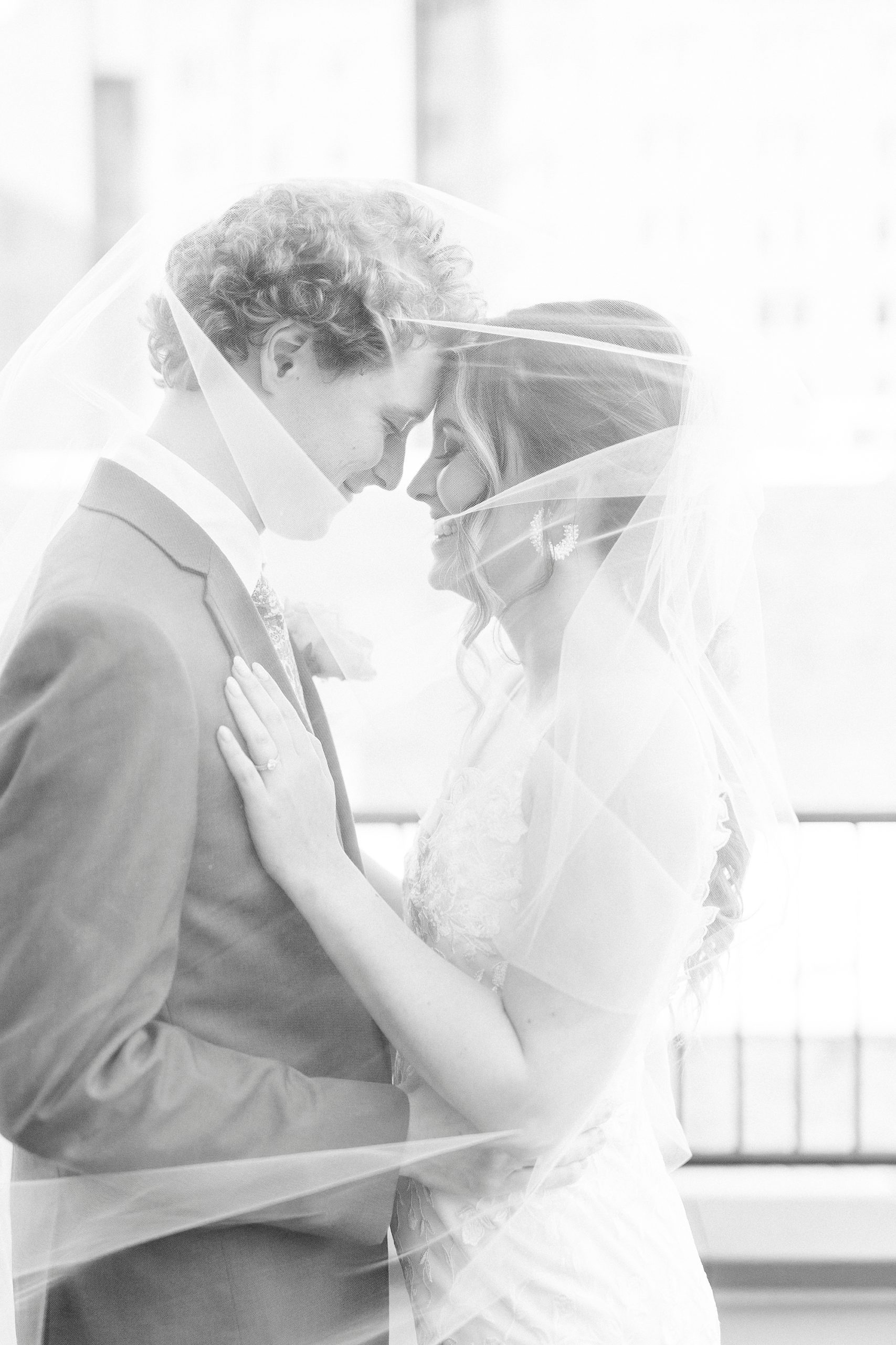 bride and groom hug under veil