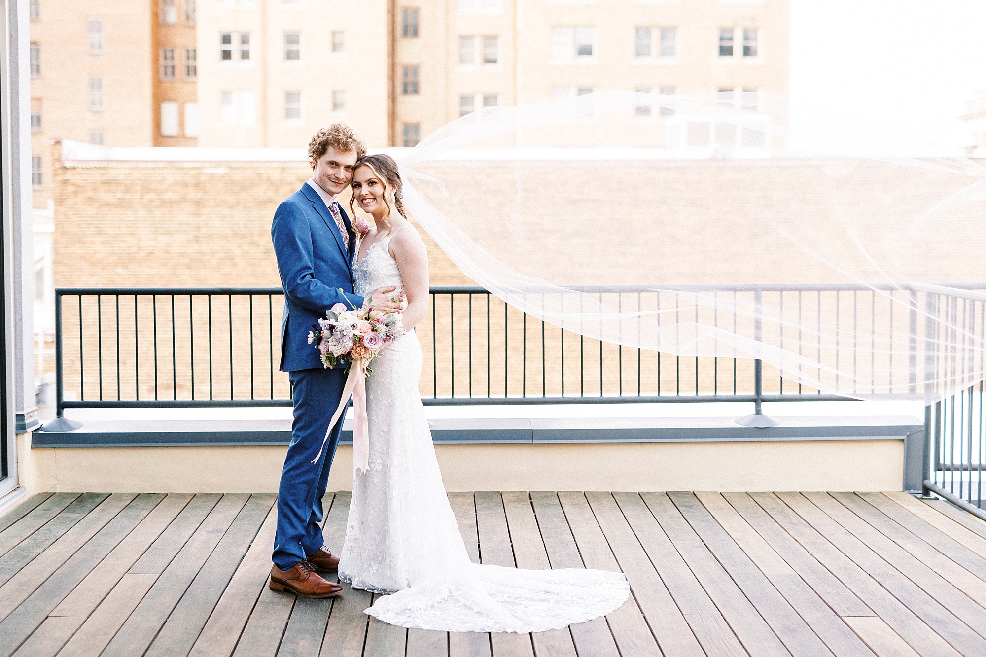 bride and groom stand together on patio at Stockroom at 230