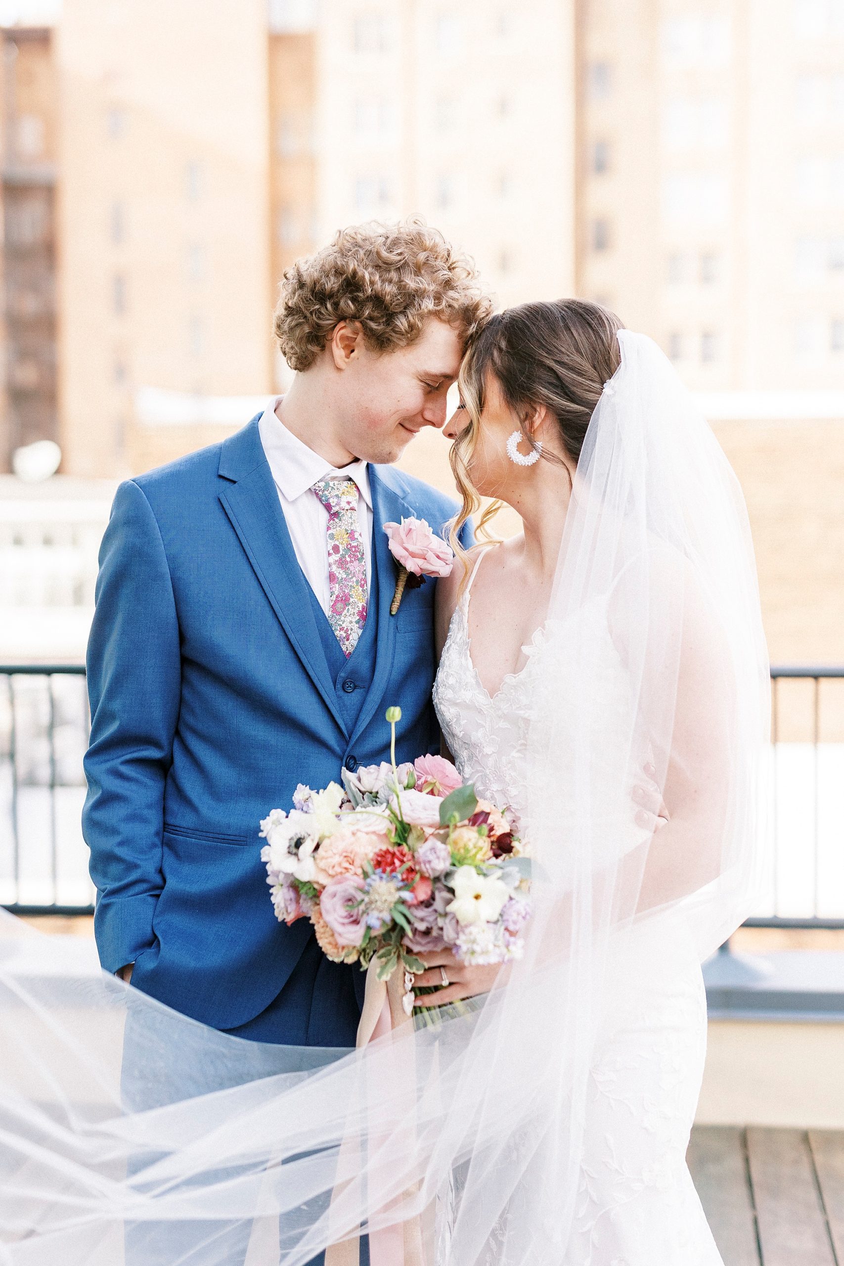 bride and groom lean together with heads touching outside the Stockroom at 230
