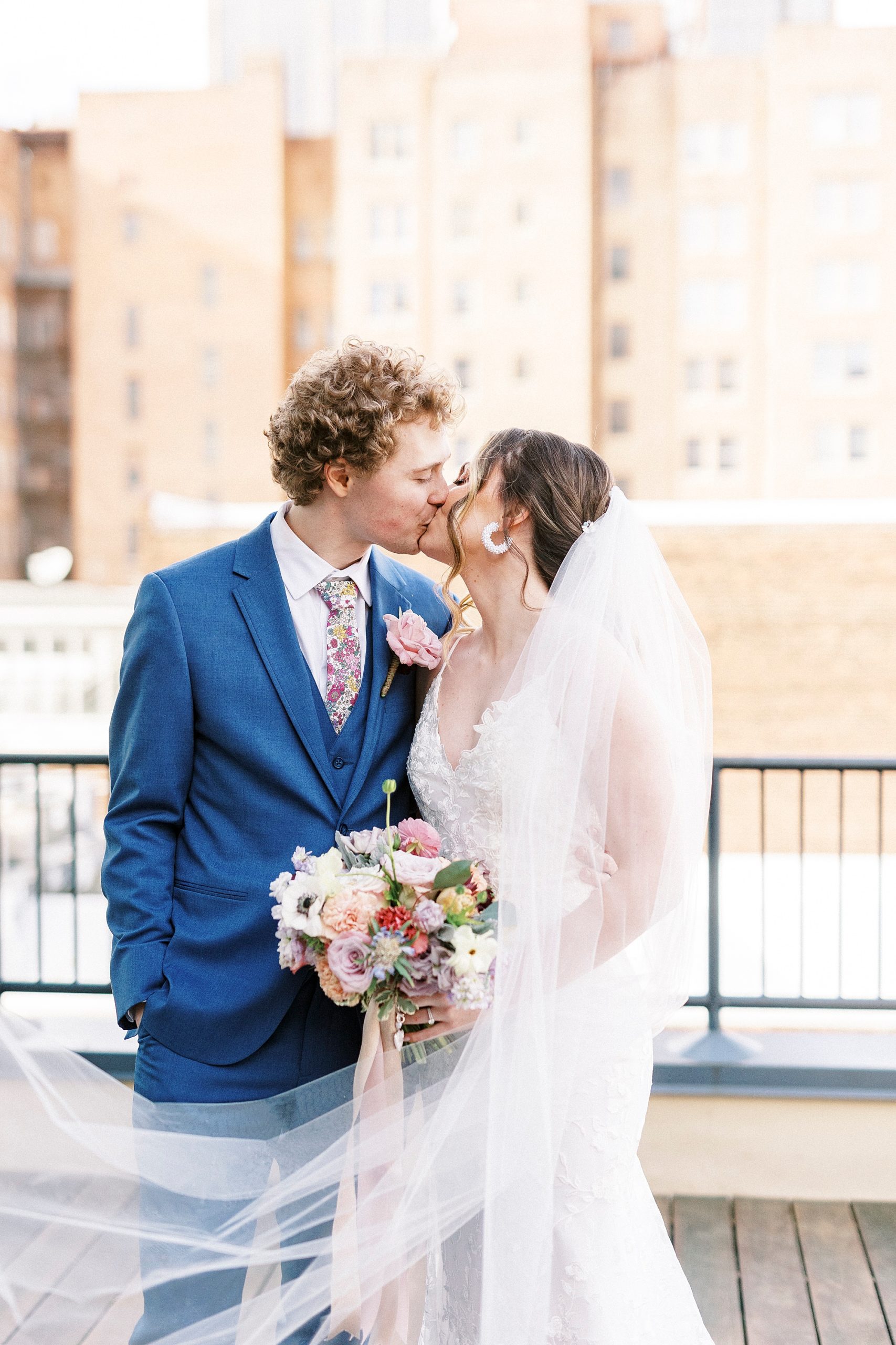 bride and groom kiss on patio at Stockroom at 230