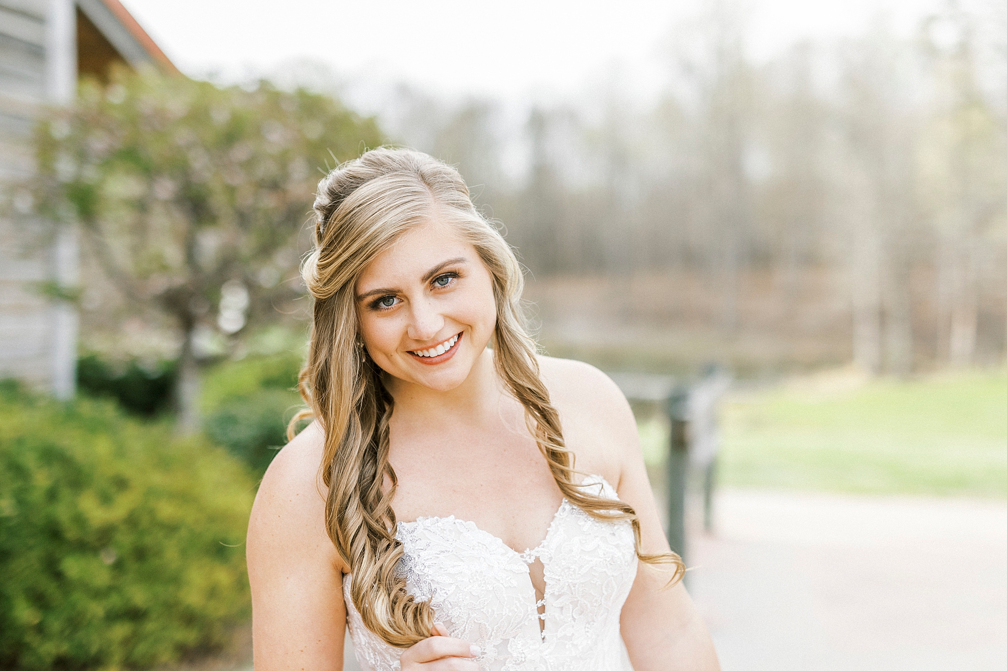 woman smiles with curls down her shoulders in strapless gown